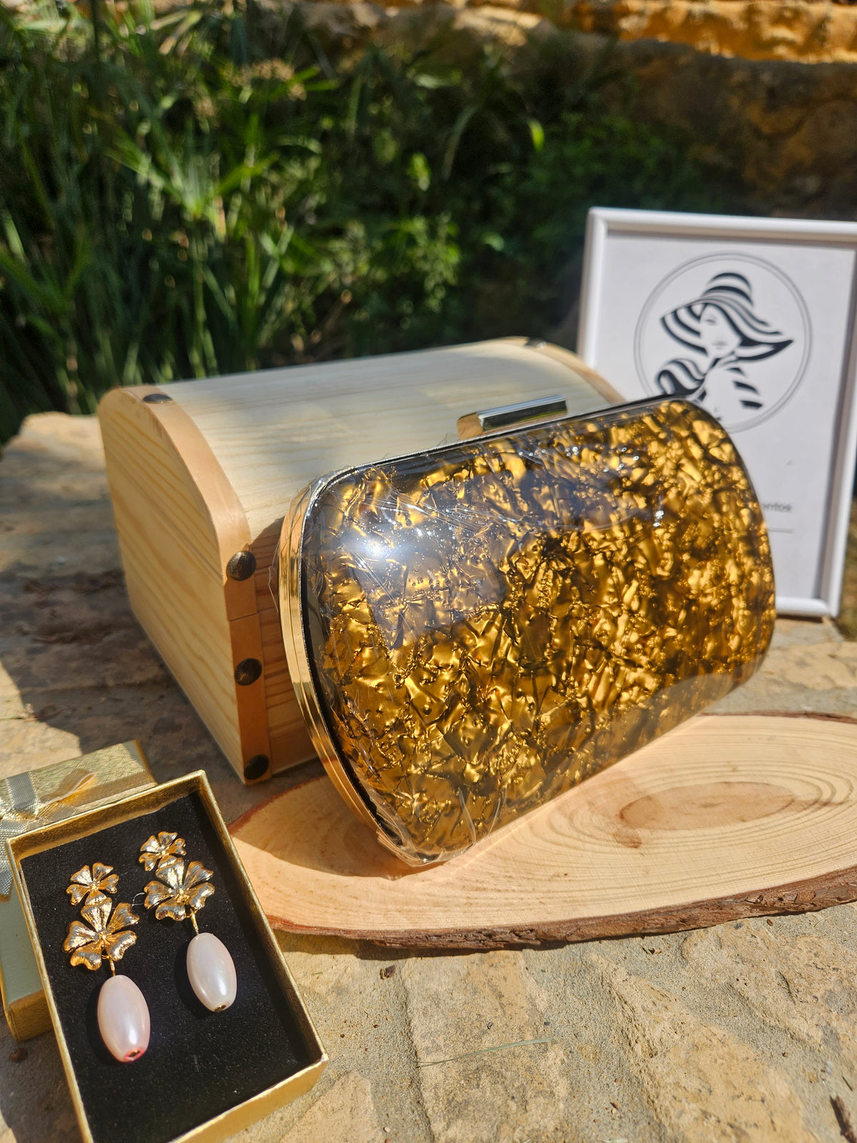 Bolso de mano dorado brillante traslúcido con cierre metálico y asa superior