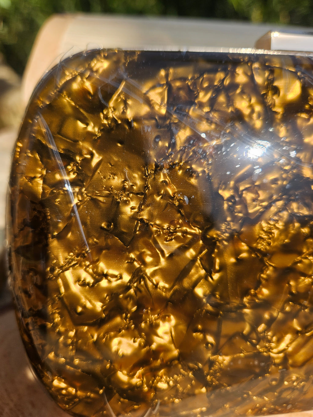 Bolso de mano dorado brillante traslúcido, primer plano del acabado reflectante
