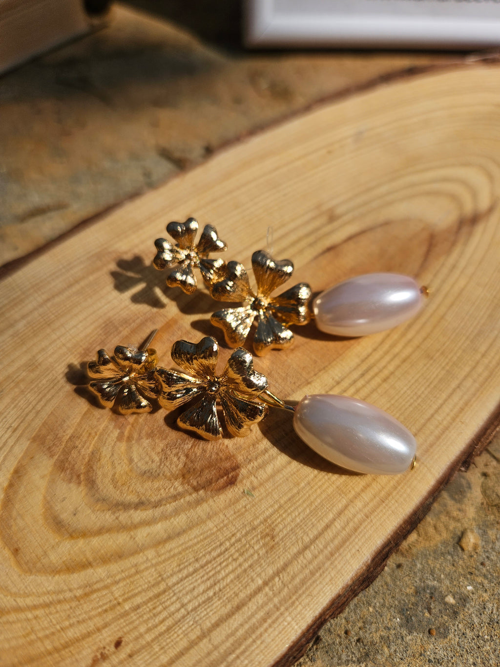 Pendientes con adornos florales dorados y colgantes blancos ovalados