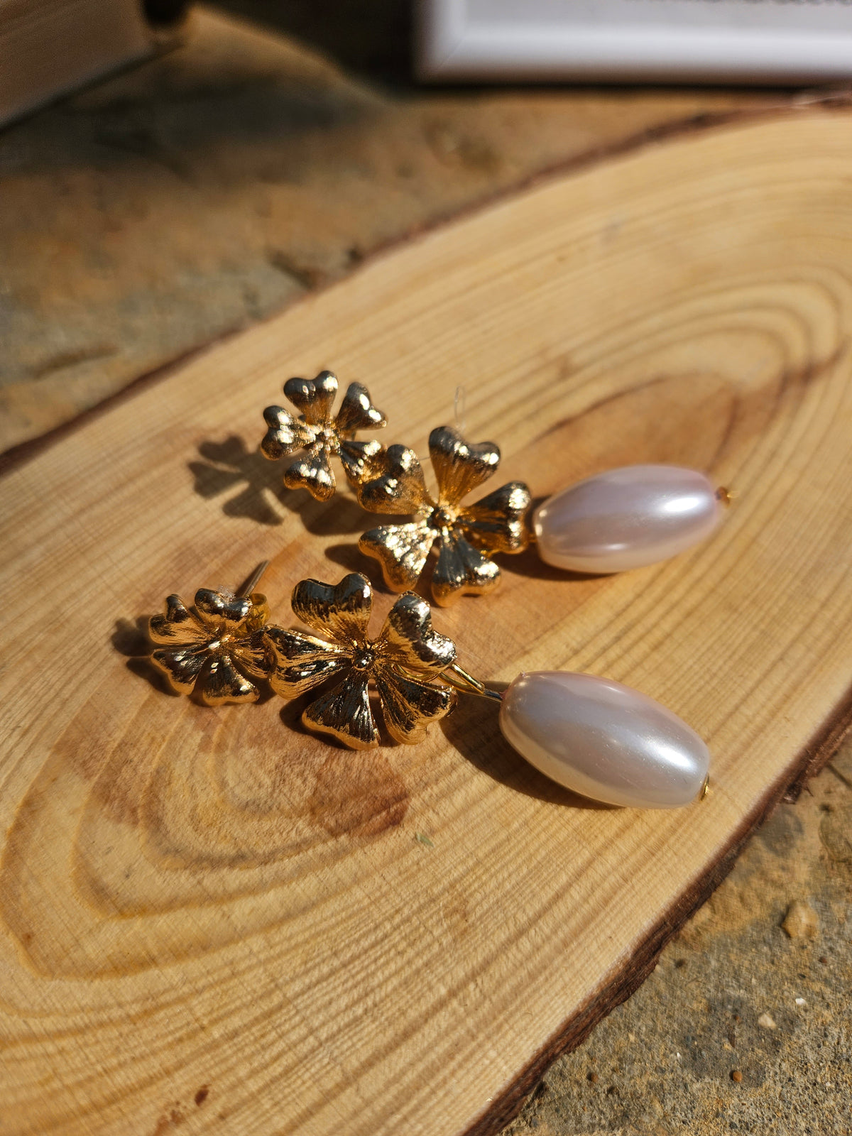 Pendientes con adornos florales dorados y colgantes blancos ovalados