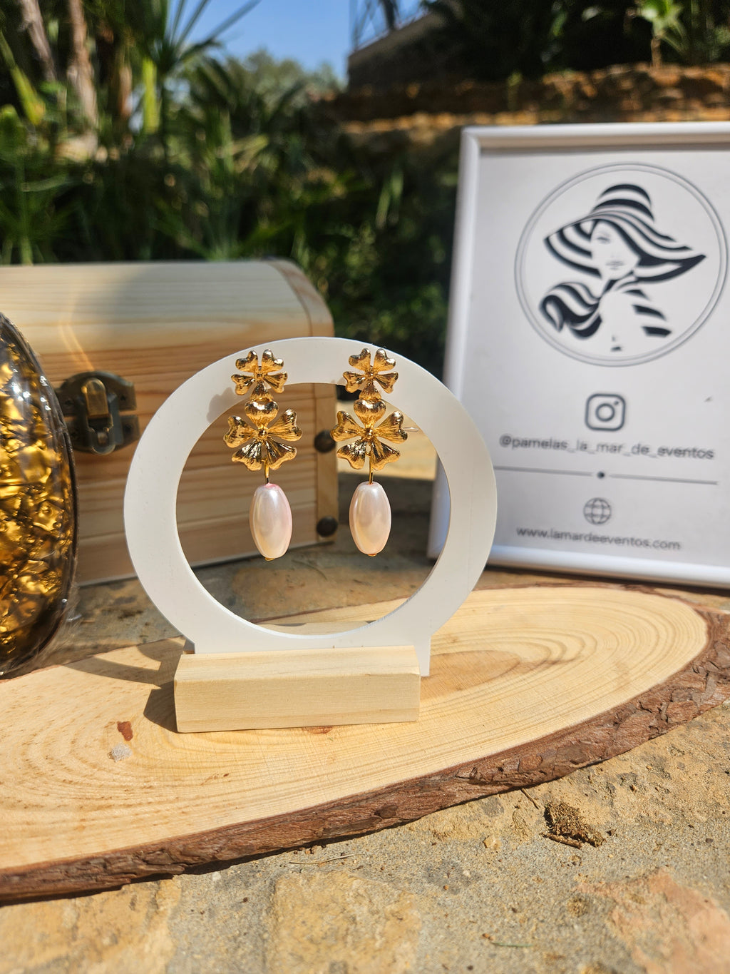 Pendientes dorados con flores y colgantes perlados blancos, en soporte