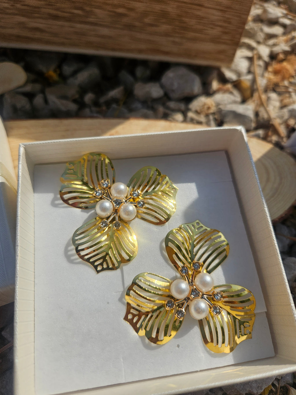 Pendientes tipo flor dorada con cuentas de perla y detalles tipo hojas