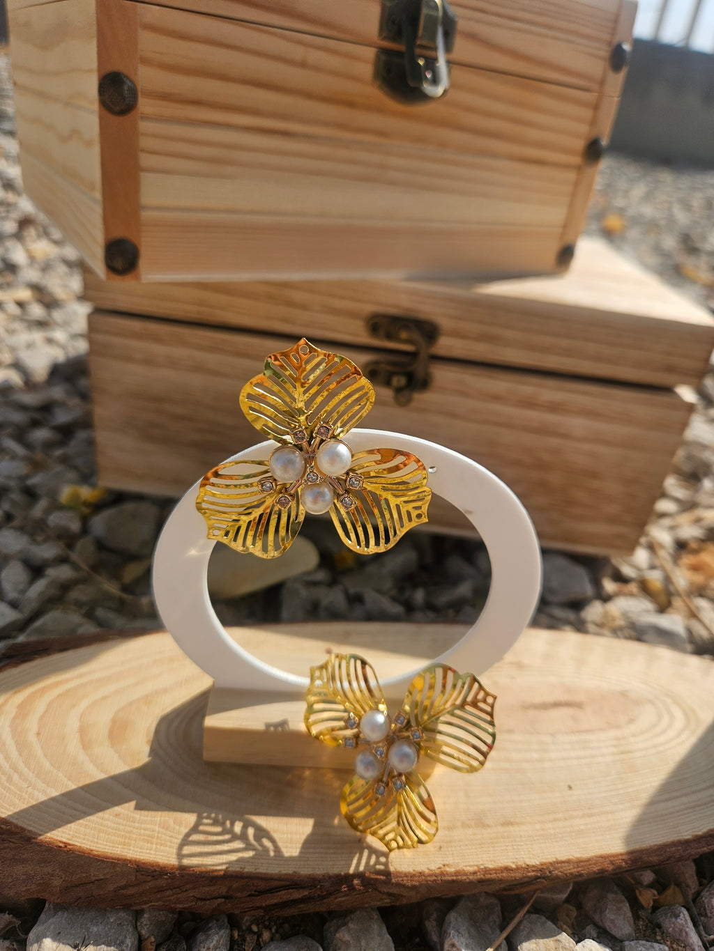 Pendientes flor dorada con nudos de perla blanca y diseño de hojas