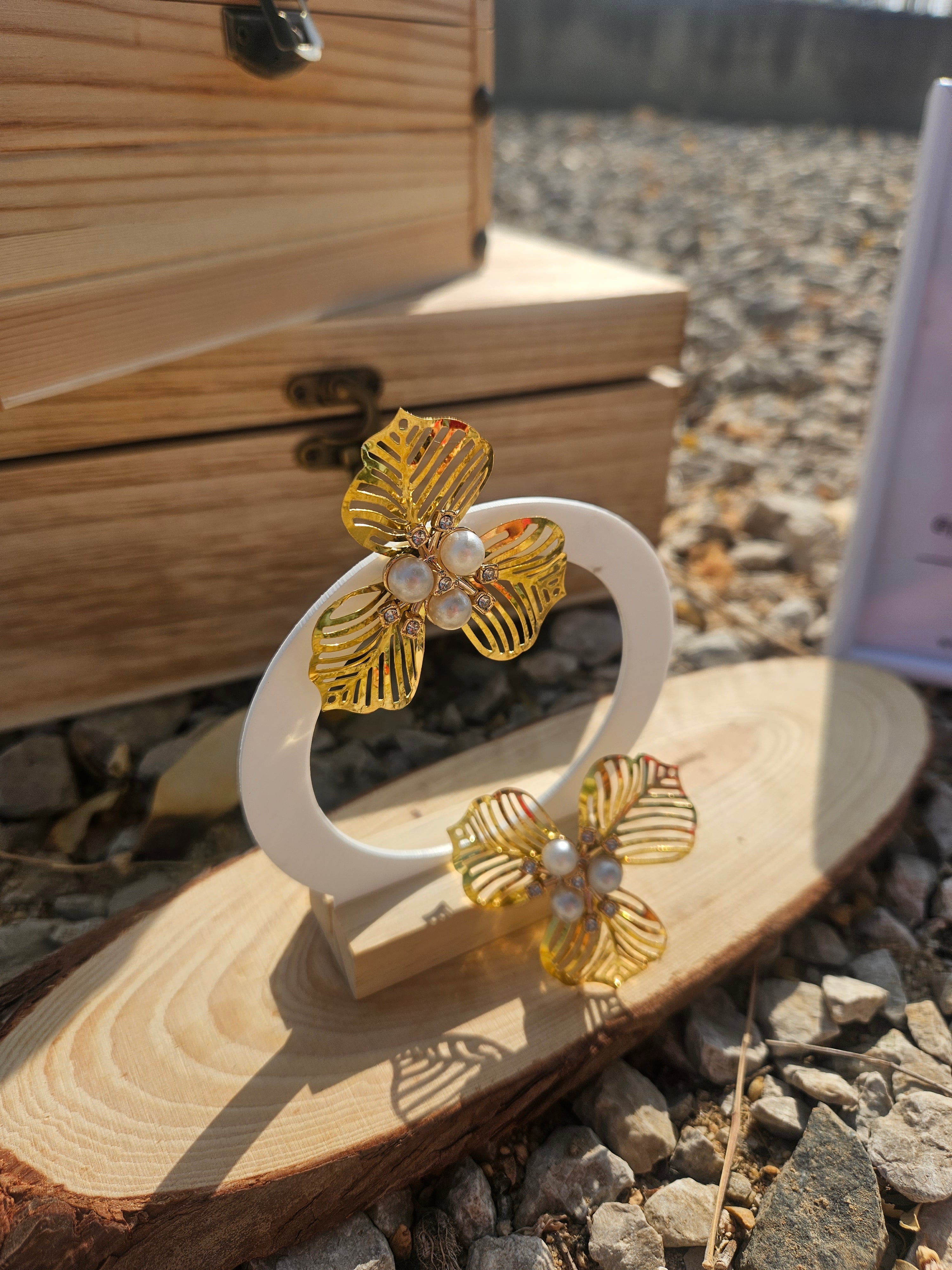 Pendientes colgantes dorados con flor de hojas y perlas blancas