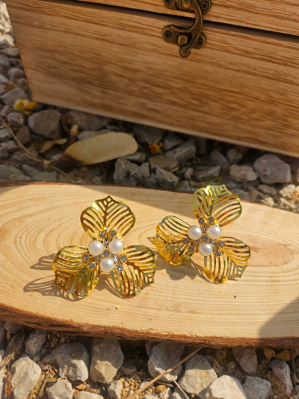 Pendientes florales dorados con perlas blancas y relieve de hojas