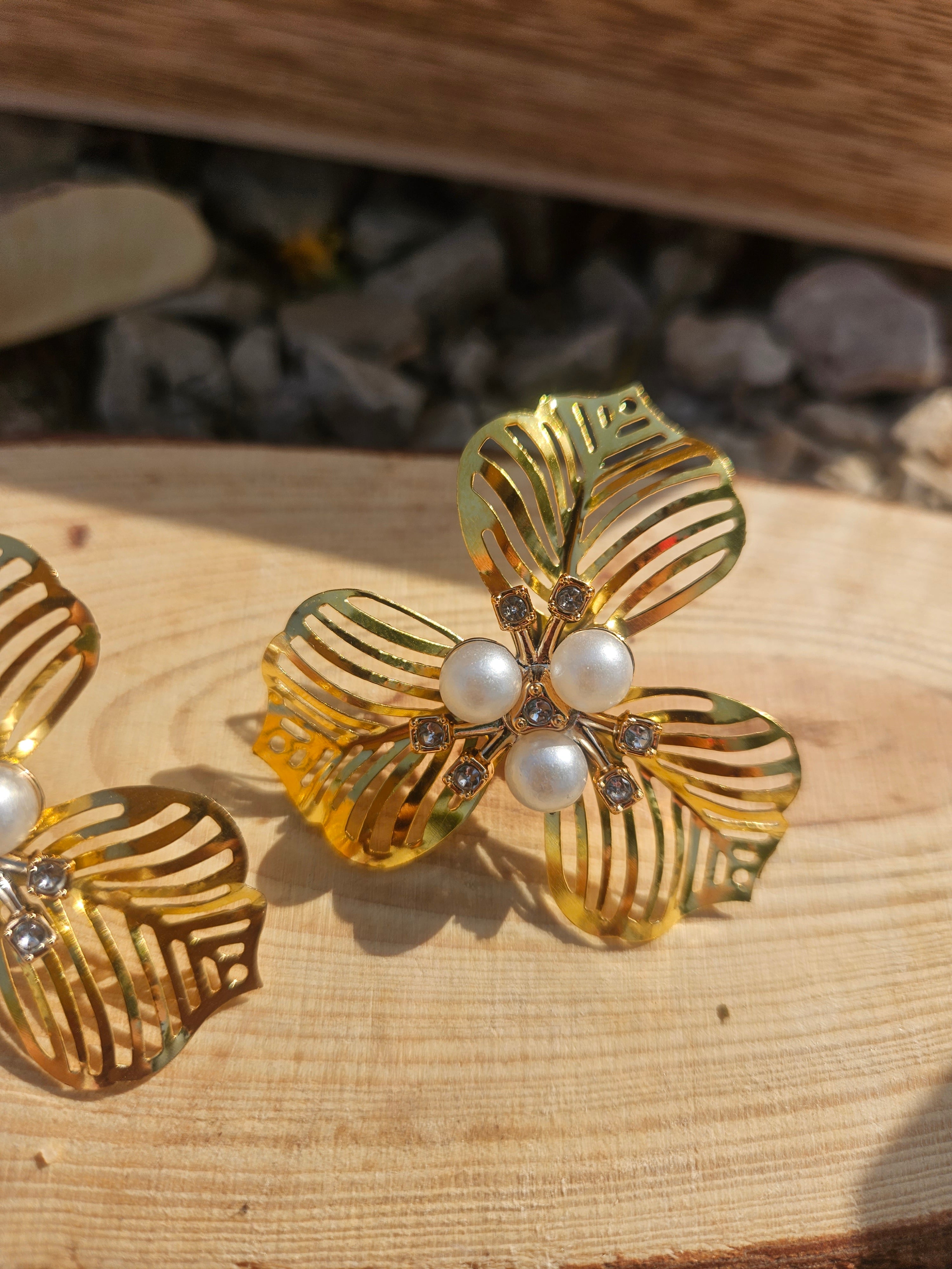 Pendientes dorados con flor triple de hojas y cuentas de perla blanca