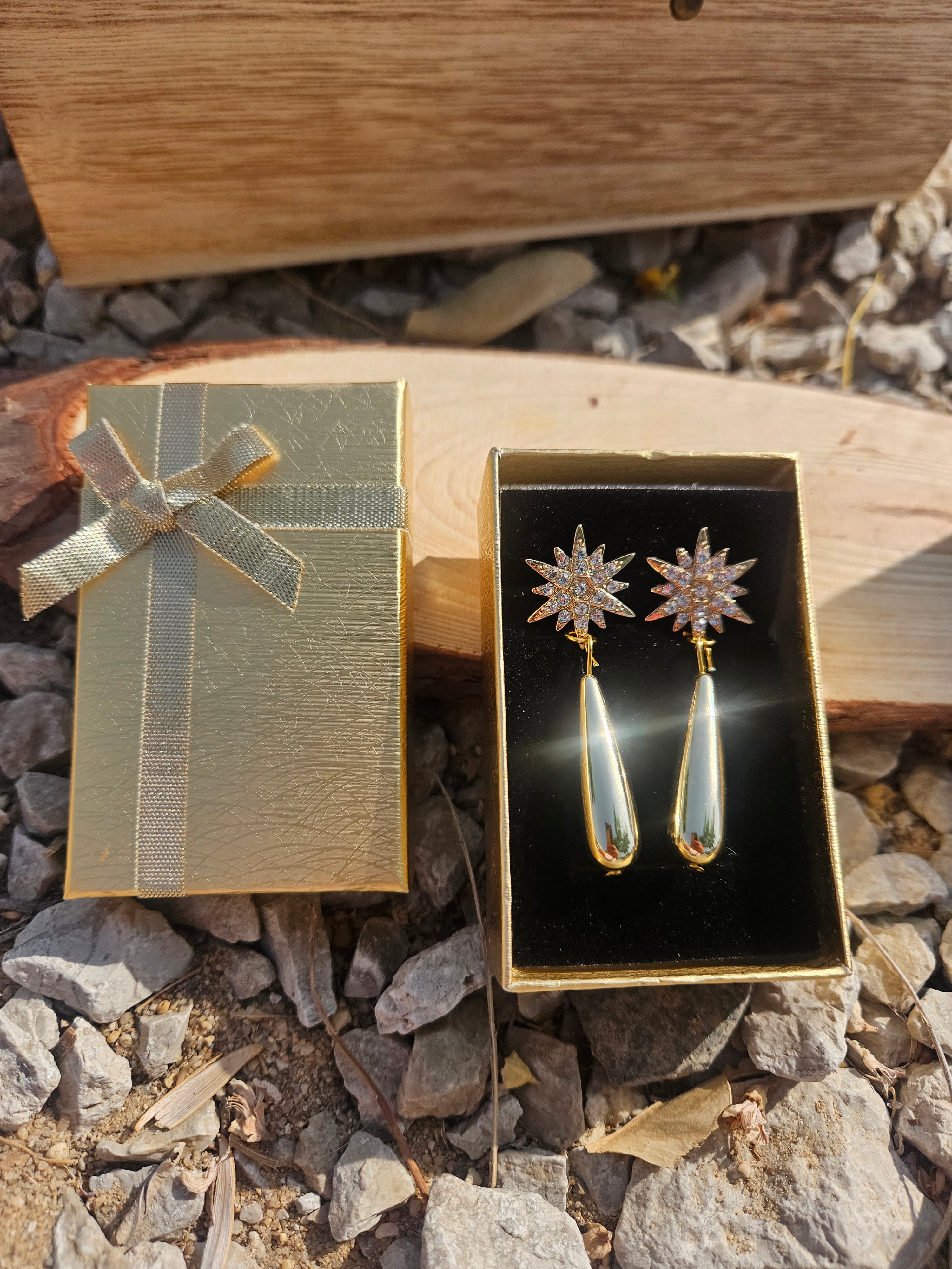 Pendientes dorados con estrella engastada y colgante lágrima, en caja regalo con lazo.