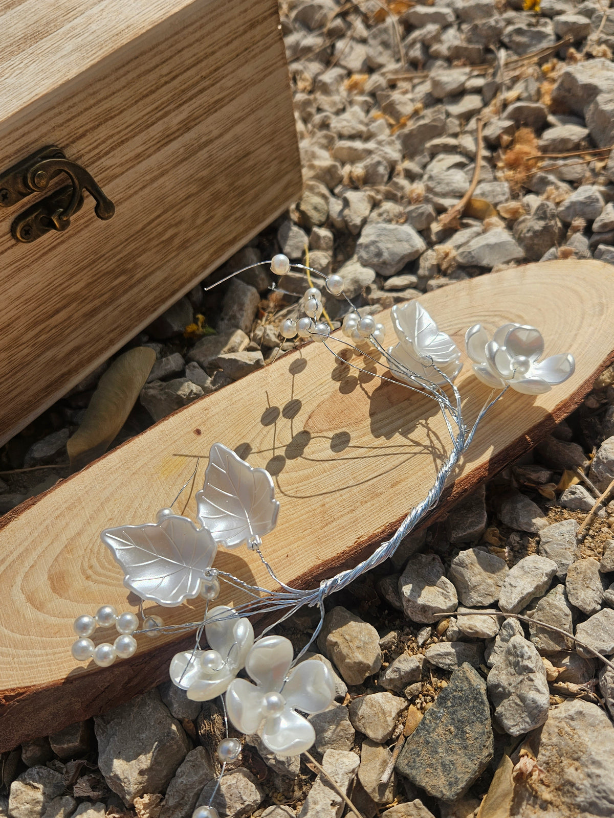 Tiara de novia plateada con flores blancas, perlas pequeñas y ramas delicadas onduladas