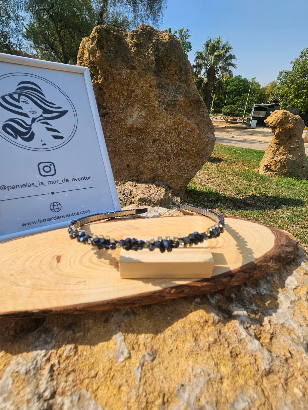 Diadema azul de pedrería y abalorios oscuros sobre banda negra