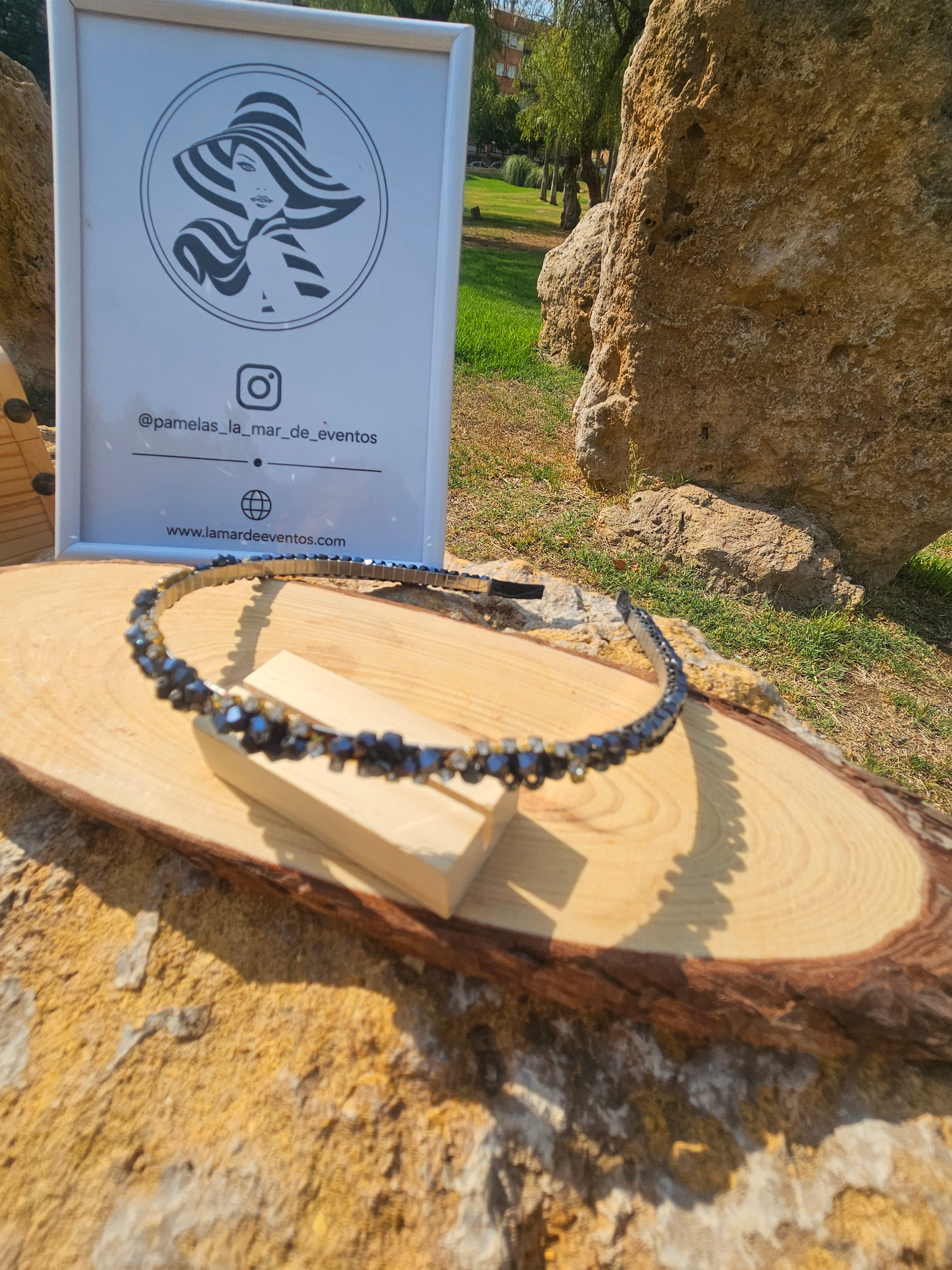 Diadema azul con pedrería brillante y abalorios oscuros, banda negra