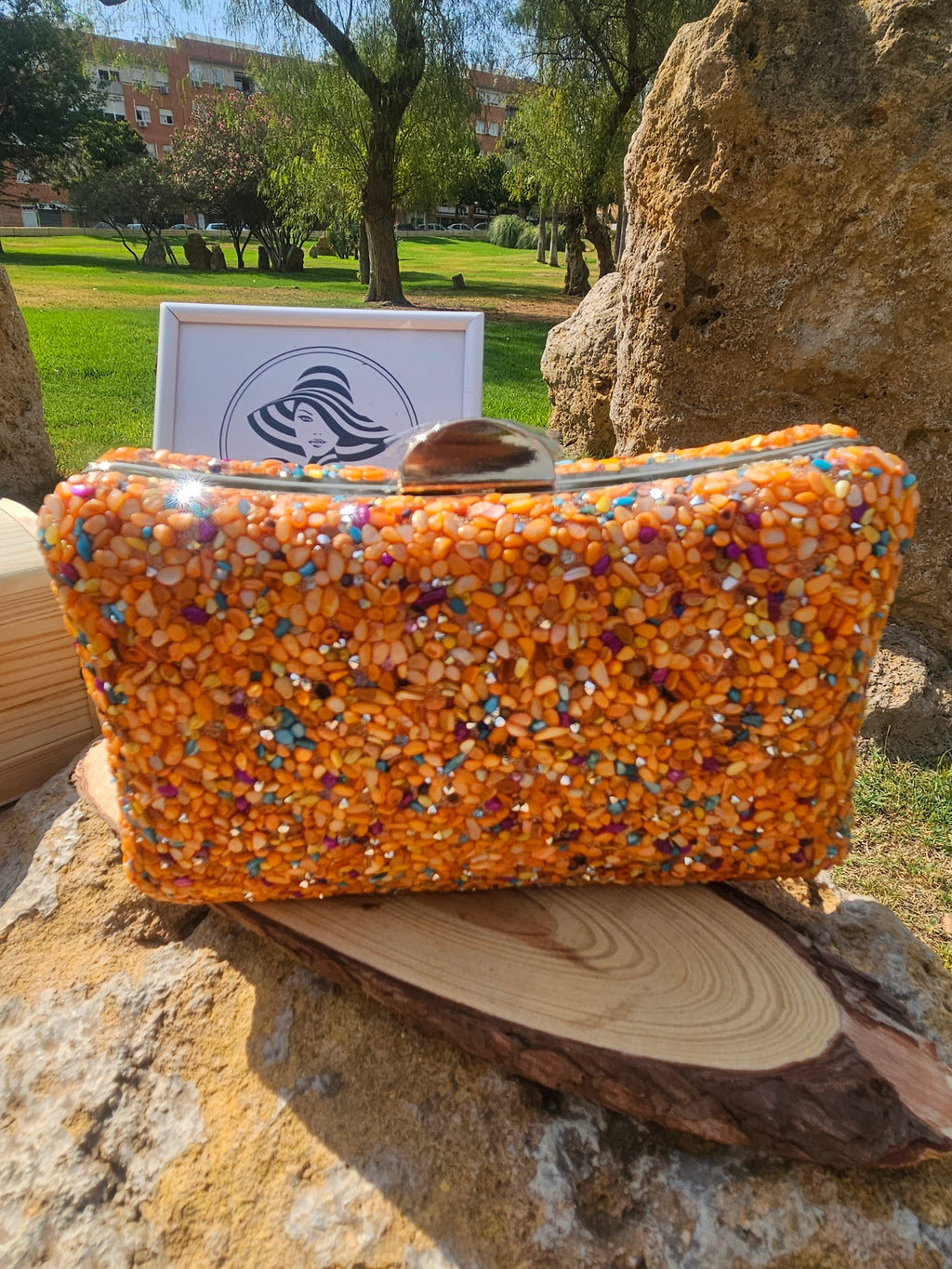 Bolso de cuentas multicolor naranja con asa superior y cierre metálico, frontal.