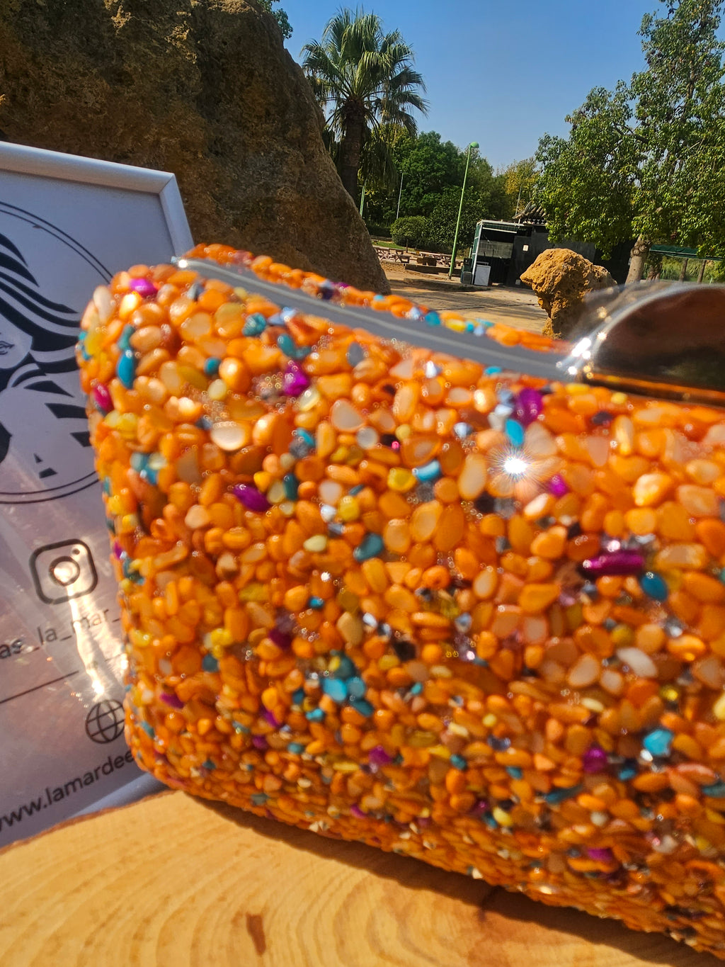 Bolso de cuentas naranjas multicolor con asa metálica, primer plano delantera.