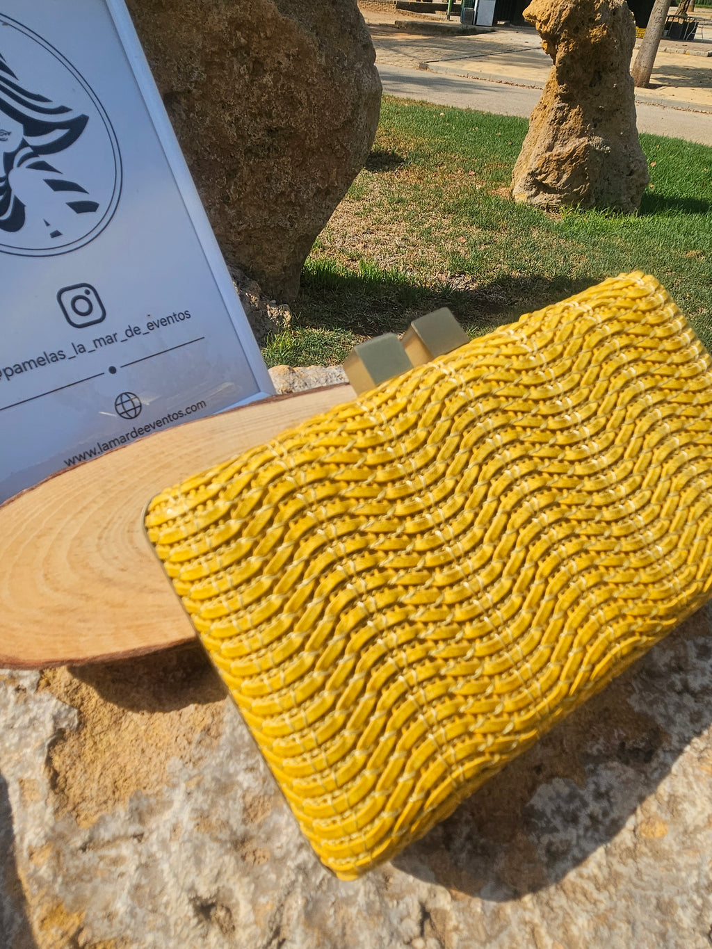Bolso Miami en amarillo mostaza, clutch de tejido trenzado con cierre metálico dorado.