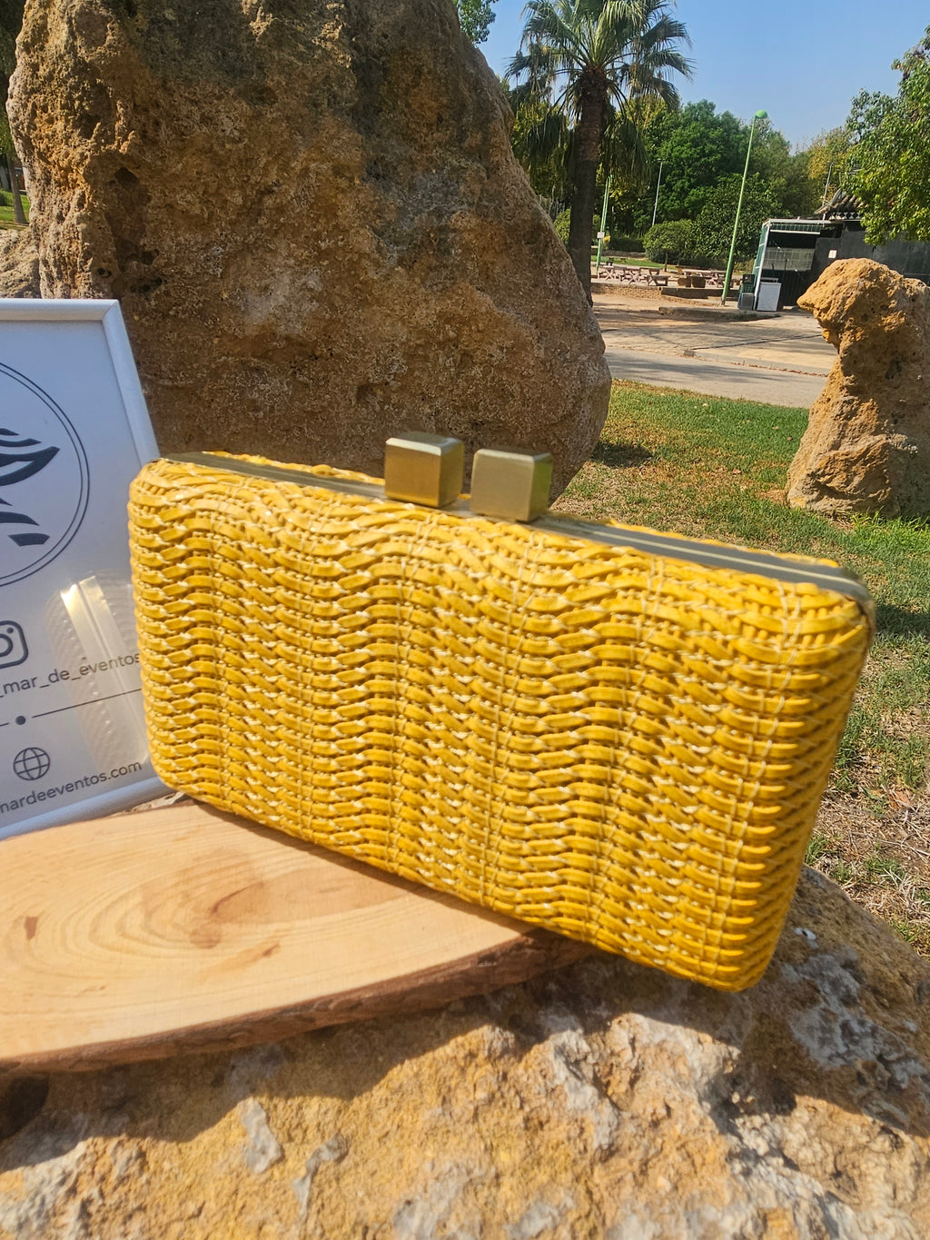 Bolso Miami rectangular amarillo de tejido trenzado, con cierre metálico y bordes firmes.