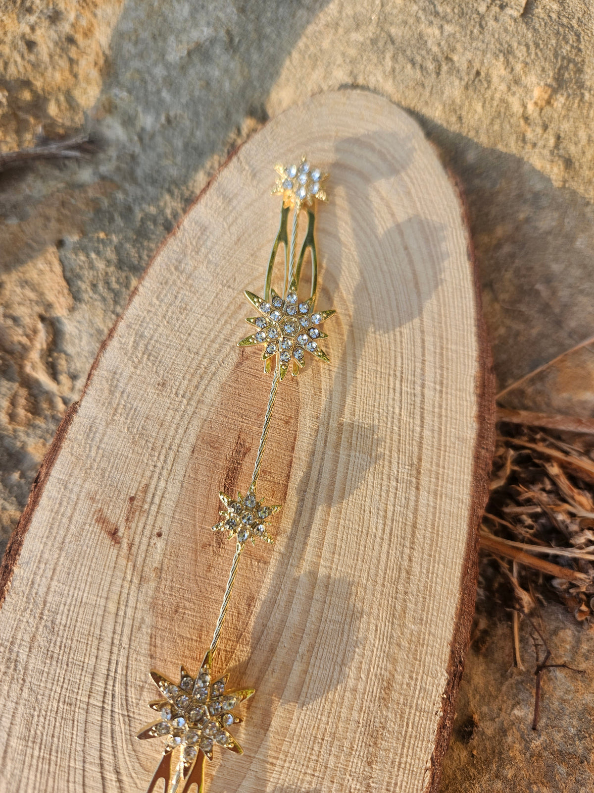Cubre raíz con adorno estelar dorado y pedrería sobre base oval de madera