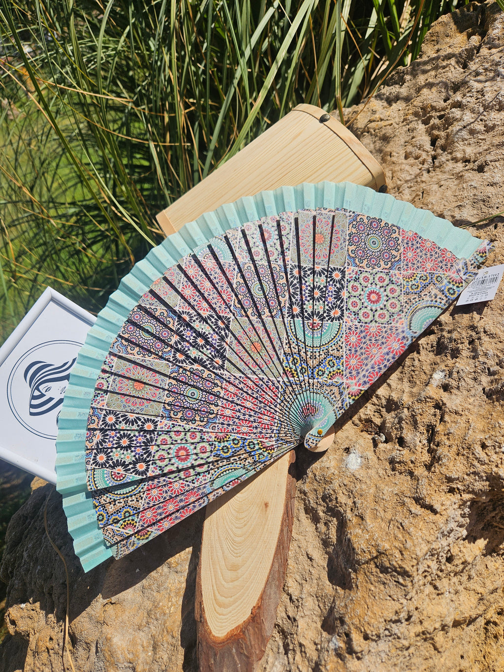Abanico geométrico verde agua con diseño floral multicolor y varillas de madera