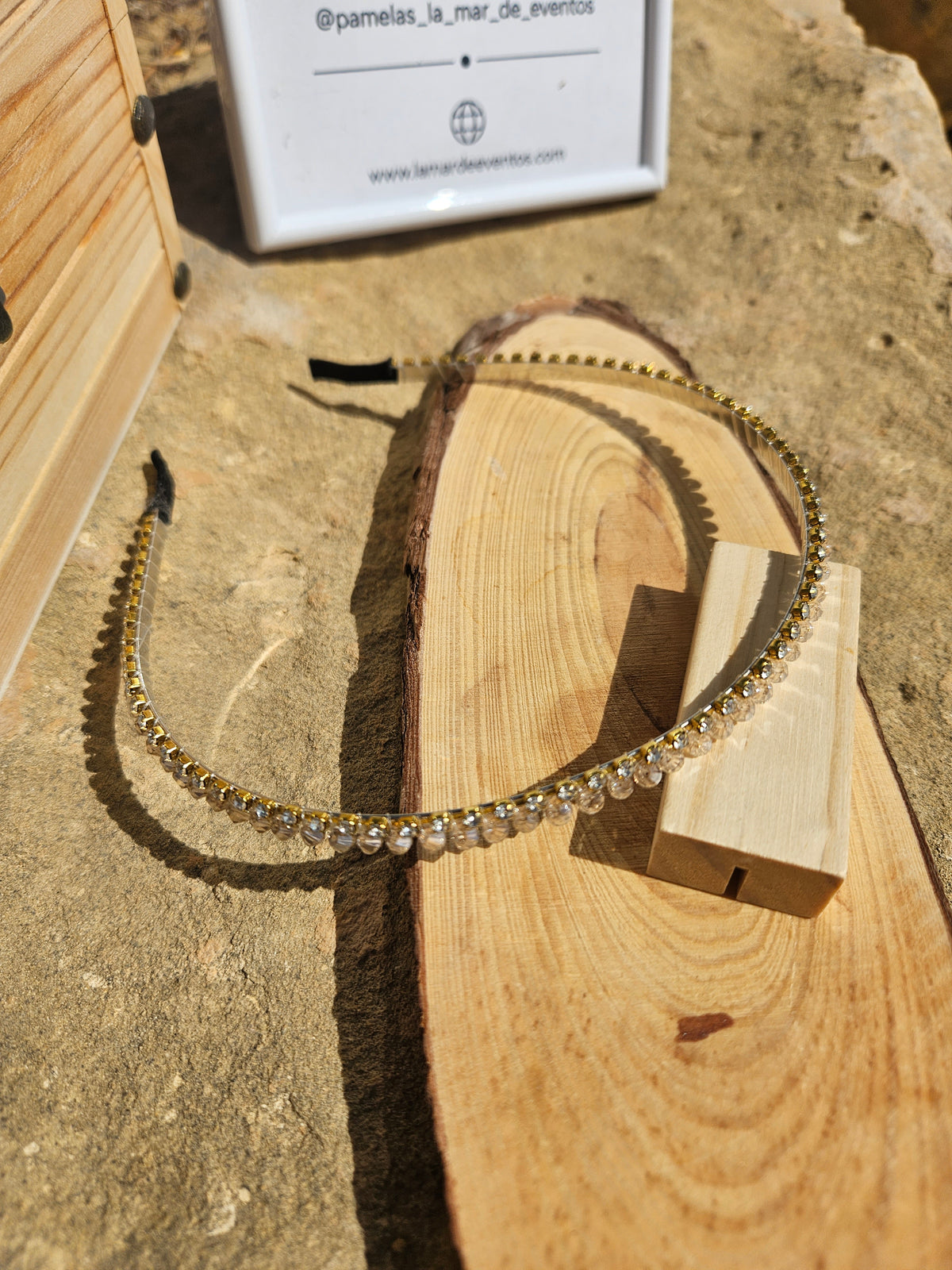 Diadema de pedrería dorada con marco fino y piedras transparentes