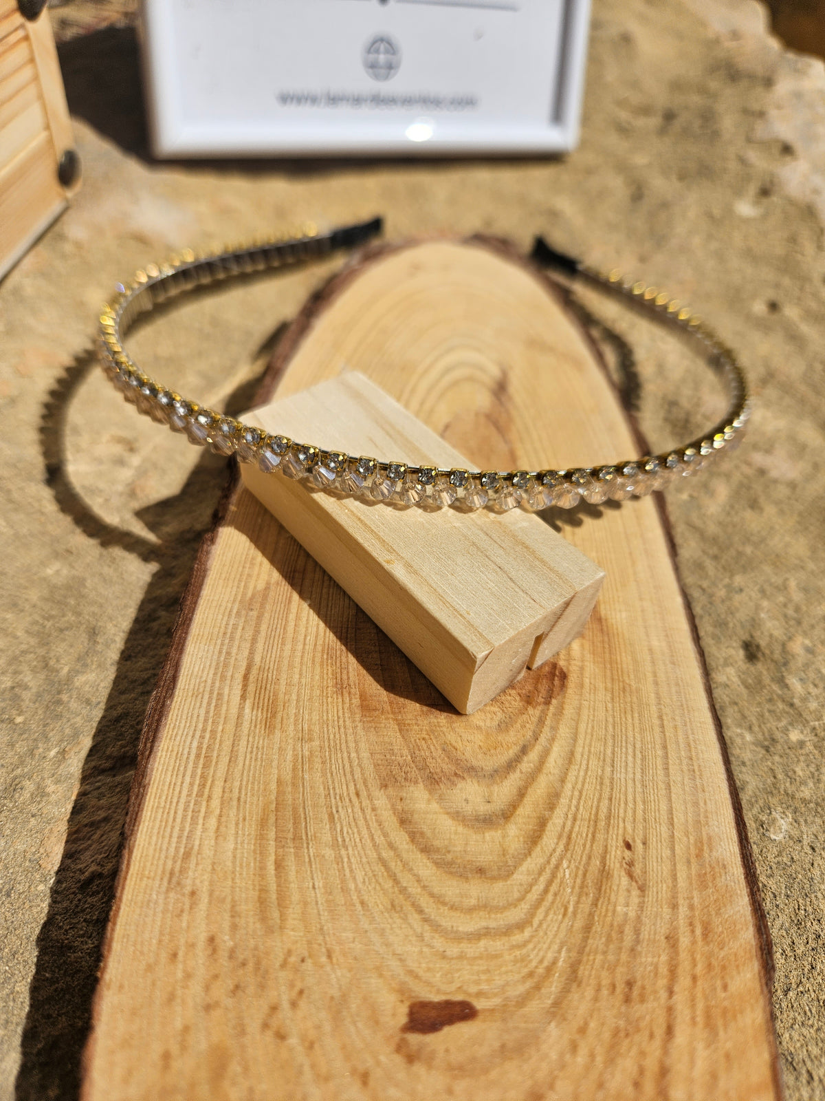 Diadema fina con pedrería dorada y piedras brillantes, vista frontal