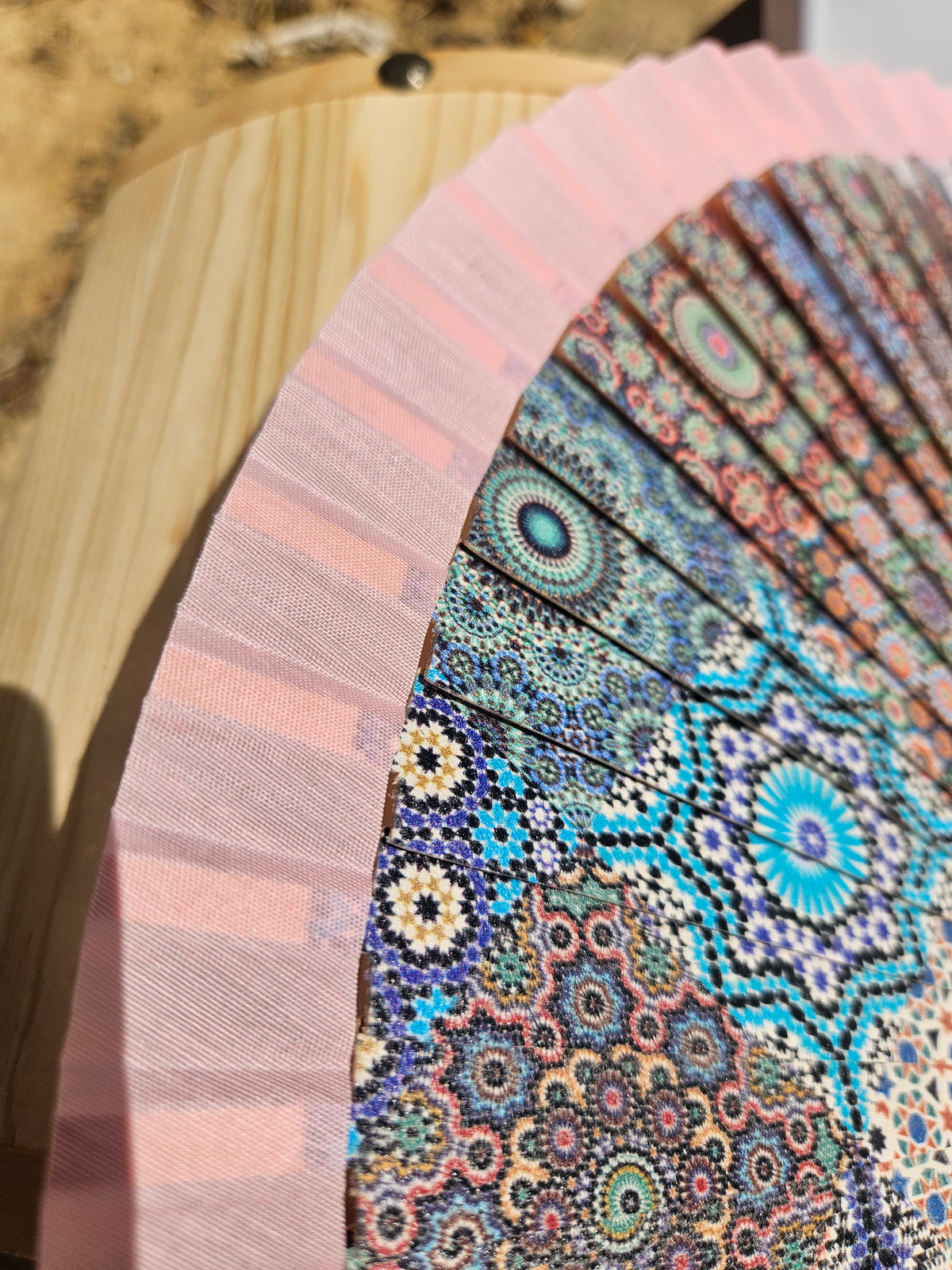 Abanico geométrico rosa con borde rosa y patrón mandala en azul