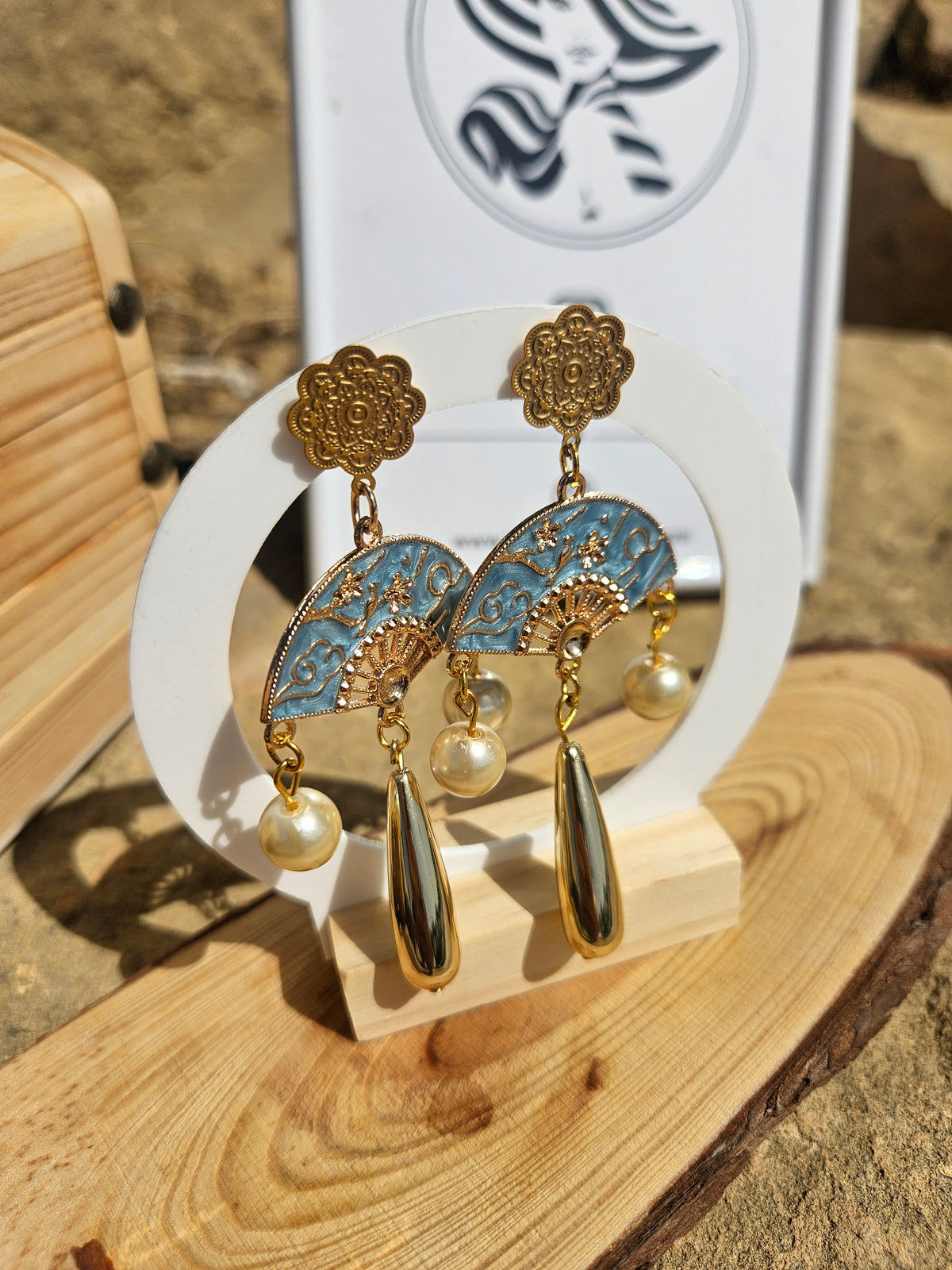 Pendientes dorados con discos azules decorados, perlas y colgantes en forma de gota