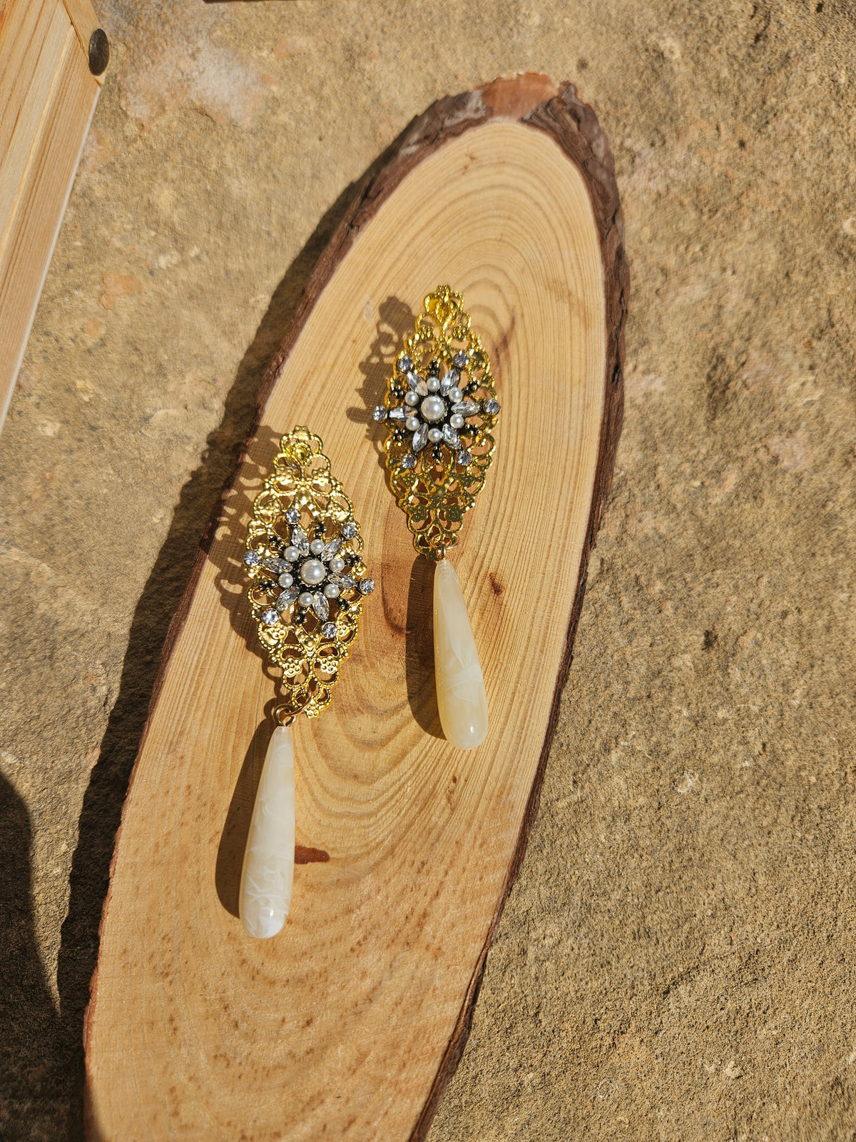 Pendientes tipo candelabro dorados con piedras y gotas marfil