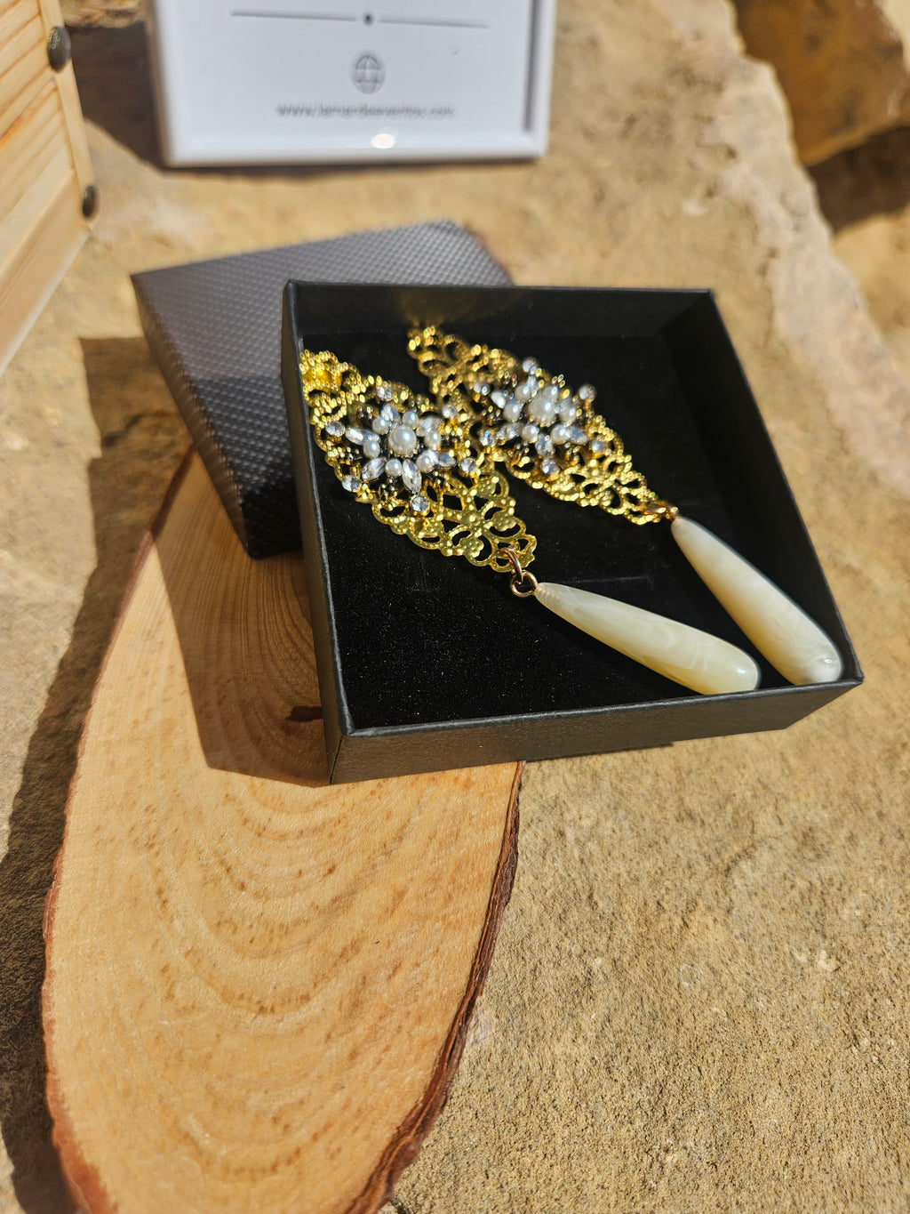 Pendientes con cadena dorada, pedrería brillante y gotas marfil