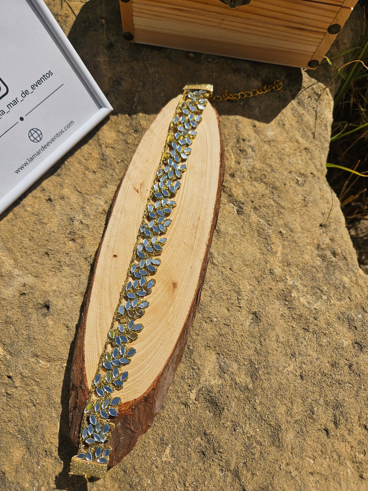Gargantilla dorada con apliques de hojas y piedras azules en forma de gota