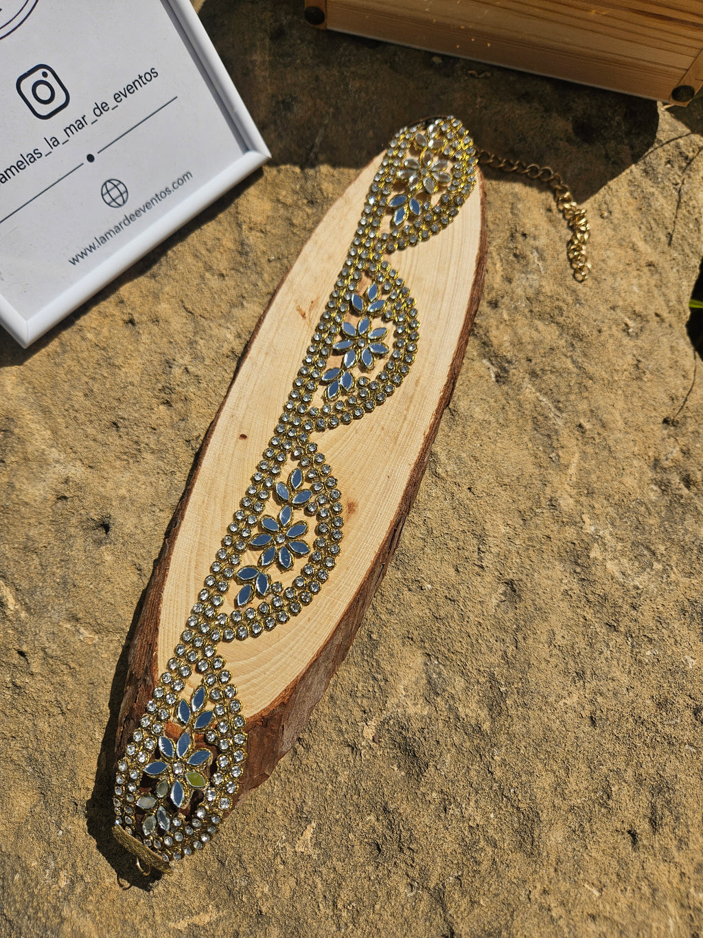 Gargantilla dorada con pedrería azul en diseño de gota y flor