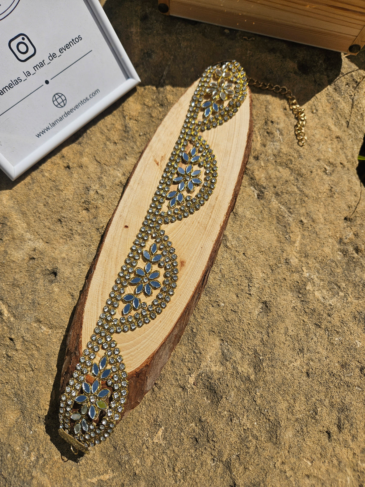 Gargantilla dorada con pedrería azul en diseño de gota y flor