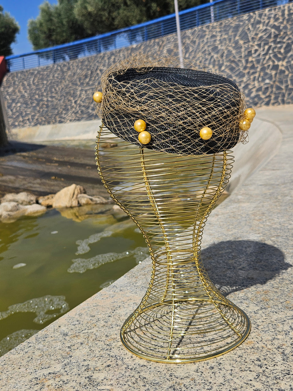 Sombrero fascinador negro con malla dorada y cuentas redondas decorativas