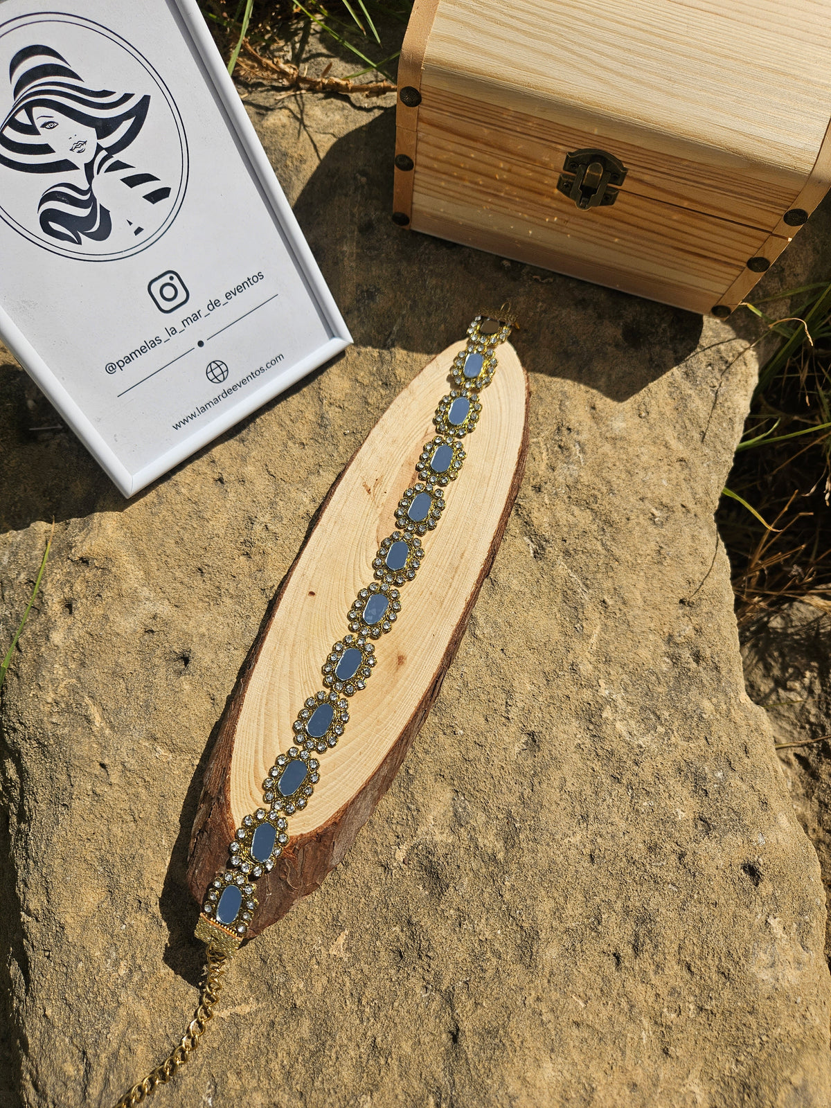 Gargantilla con pedrería ovalada azul y detalles dorados sobre tablita de madera