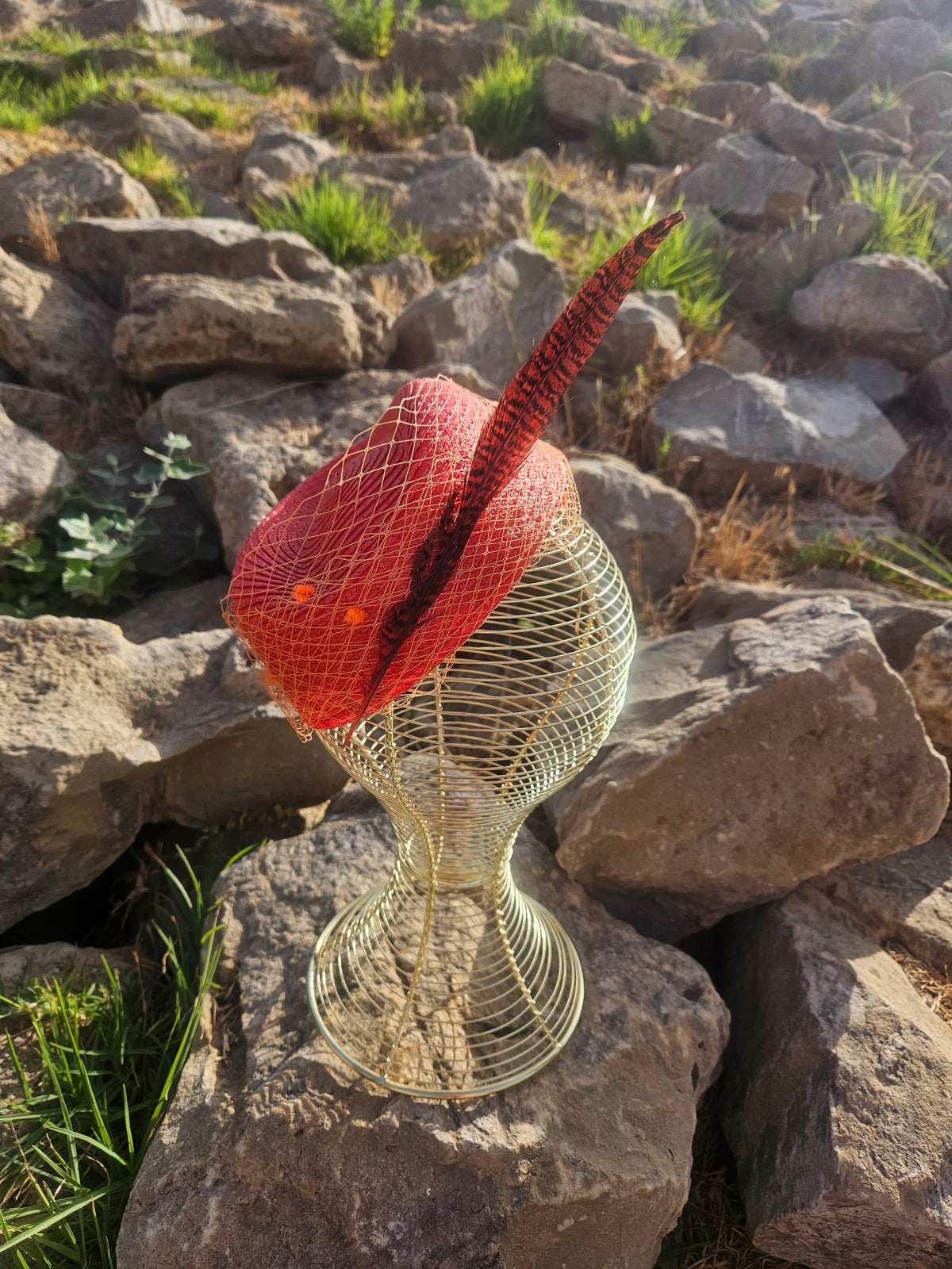 Sombrero Clement de malla roja con copa dorada y ala alta sobre maniquí