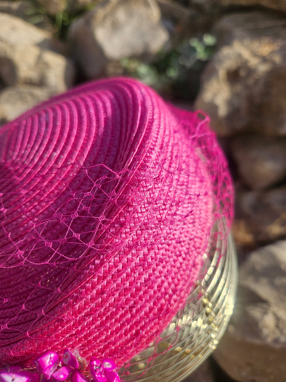 Sombrero fucsia de ala corta con detalle de malla y adorno brillante en el lateral