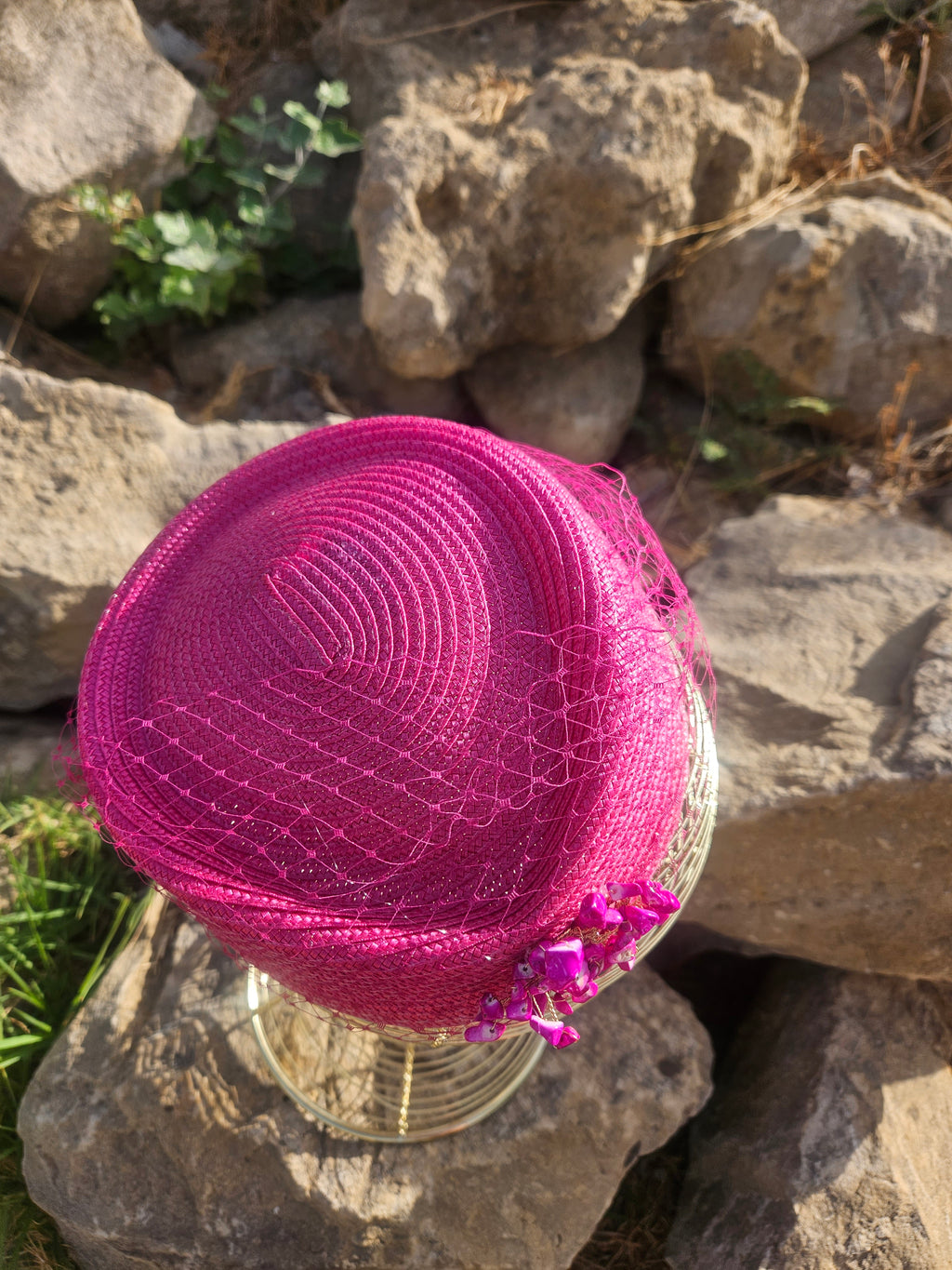 Sombrero fucsia con barboquejo de malla y adorno brillante en la parte trasera