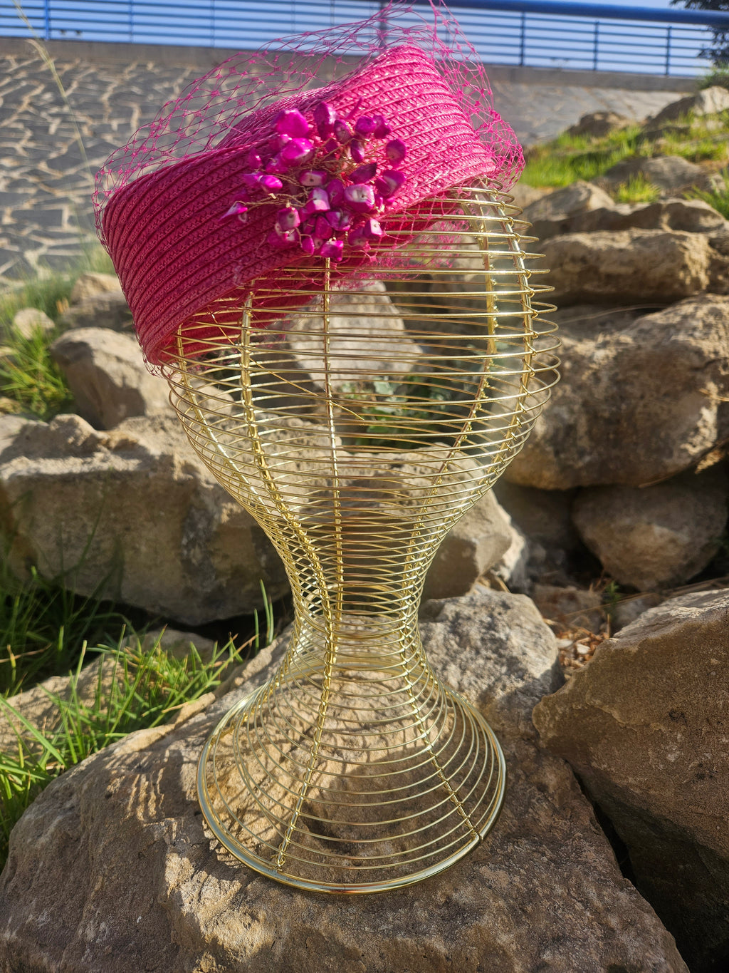 Sombrero fucsia con velo de malla, adorno floral brillante y banda lateral