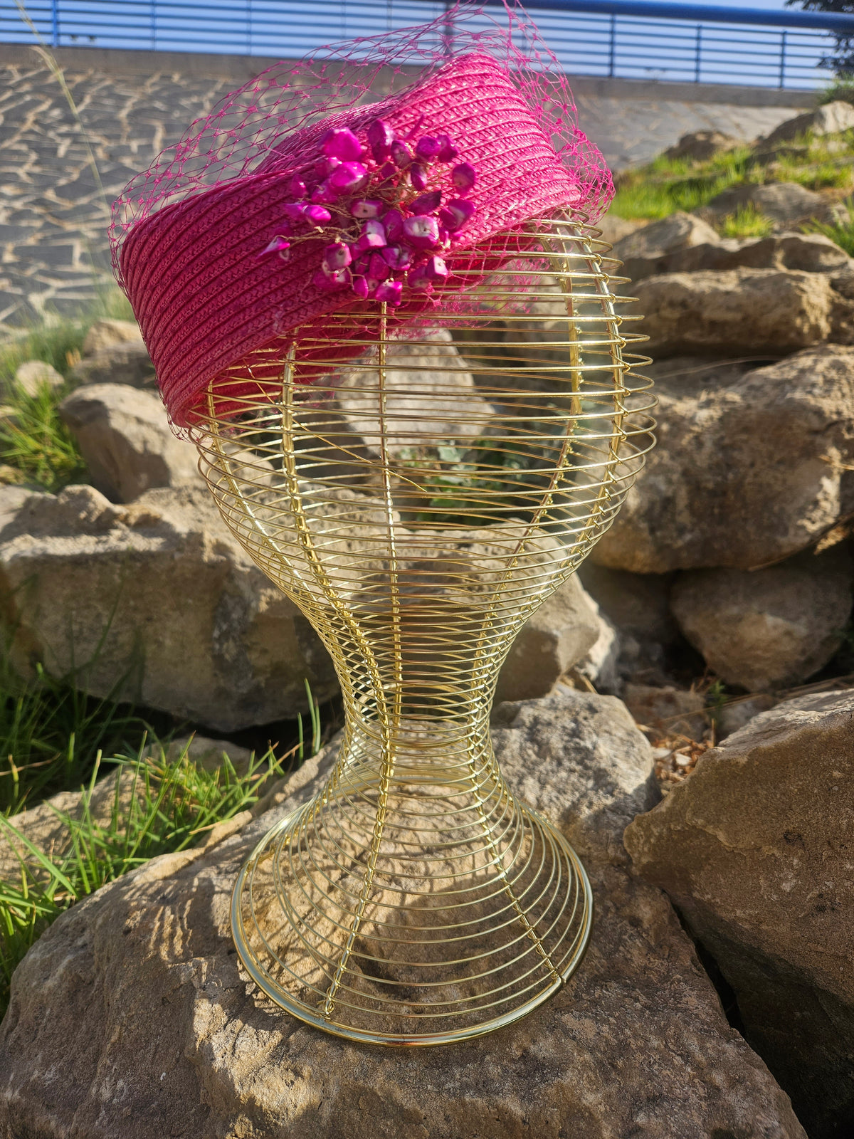 Sombrero fucsia con velo de malla, adorno floral brillante y banda lateral