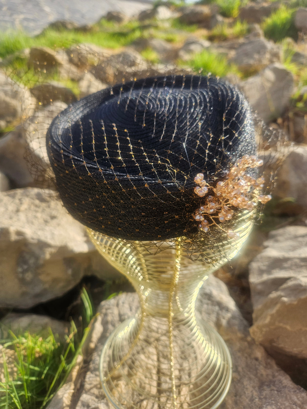 Sombrero de malla negro con flor dorada en el frente