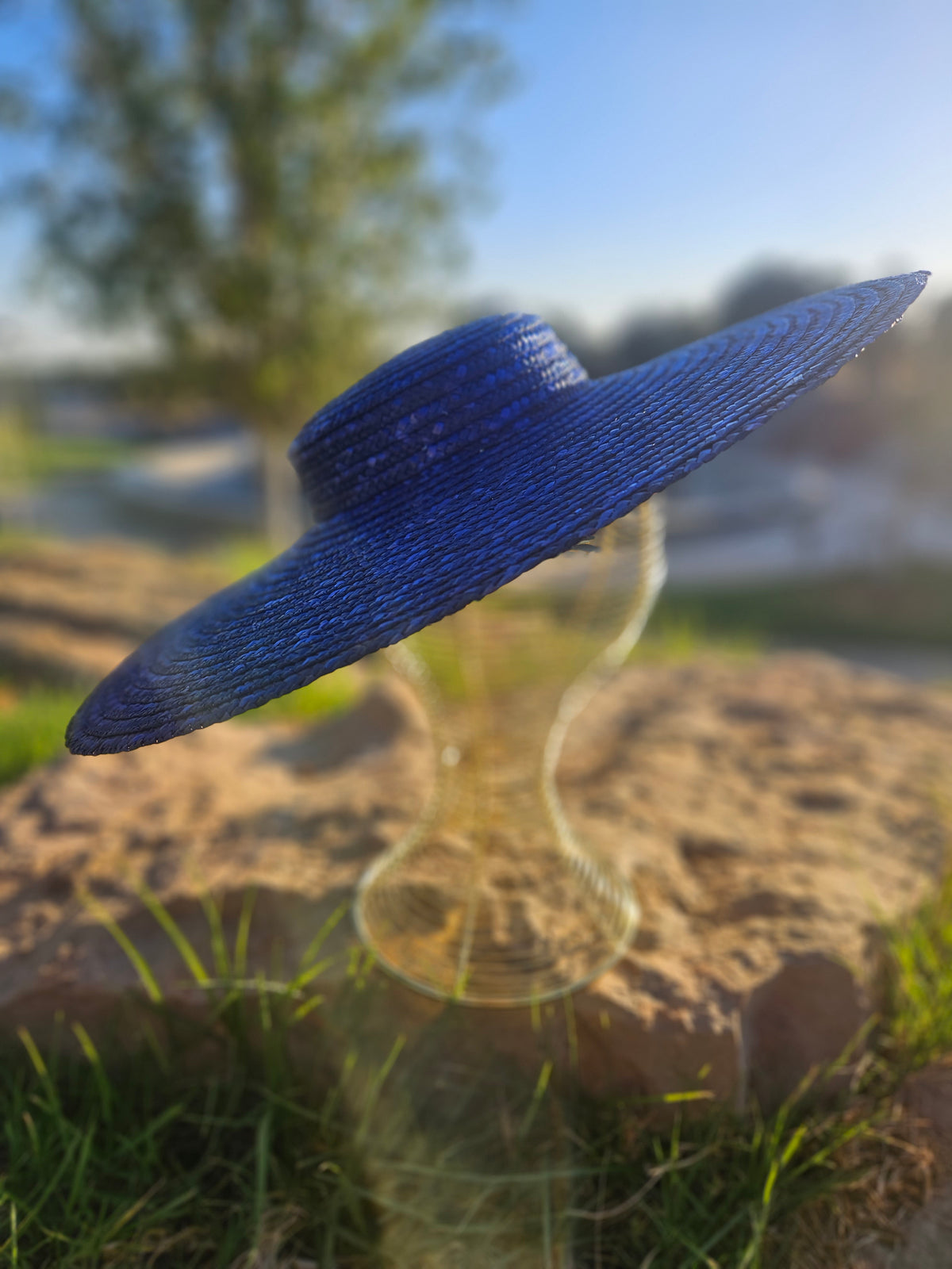 Sombrero de paja azul con ala ancha, vista lateral en ángulo.
