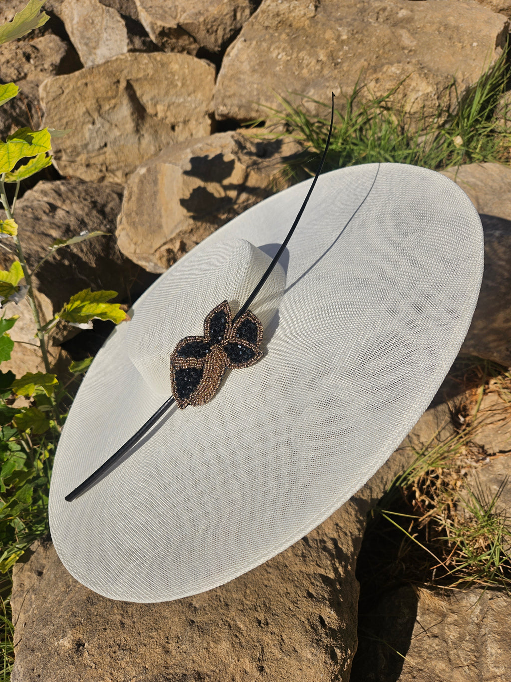Sombrero de ala ancha claro con adorno mariposa bordado negro y dorado