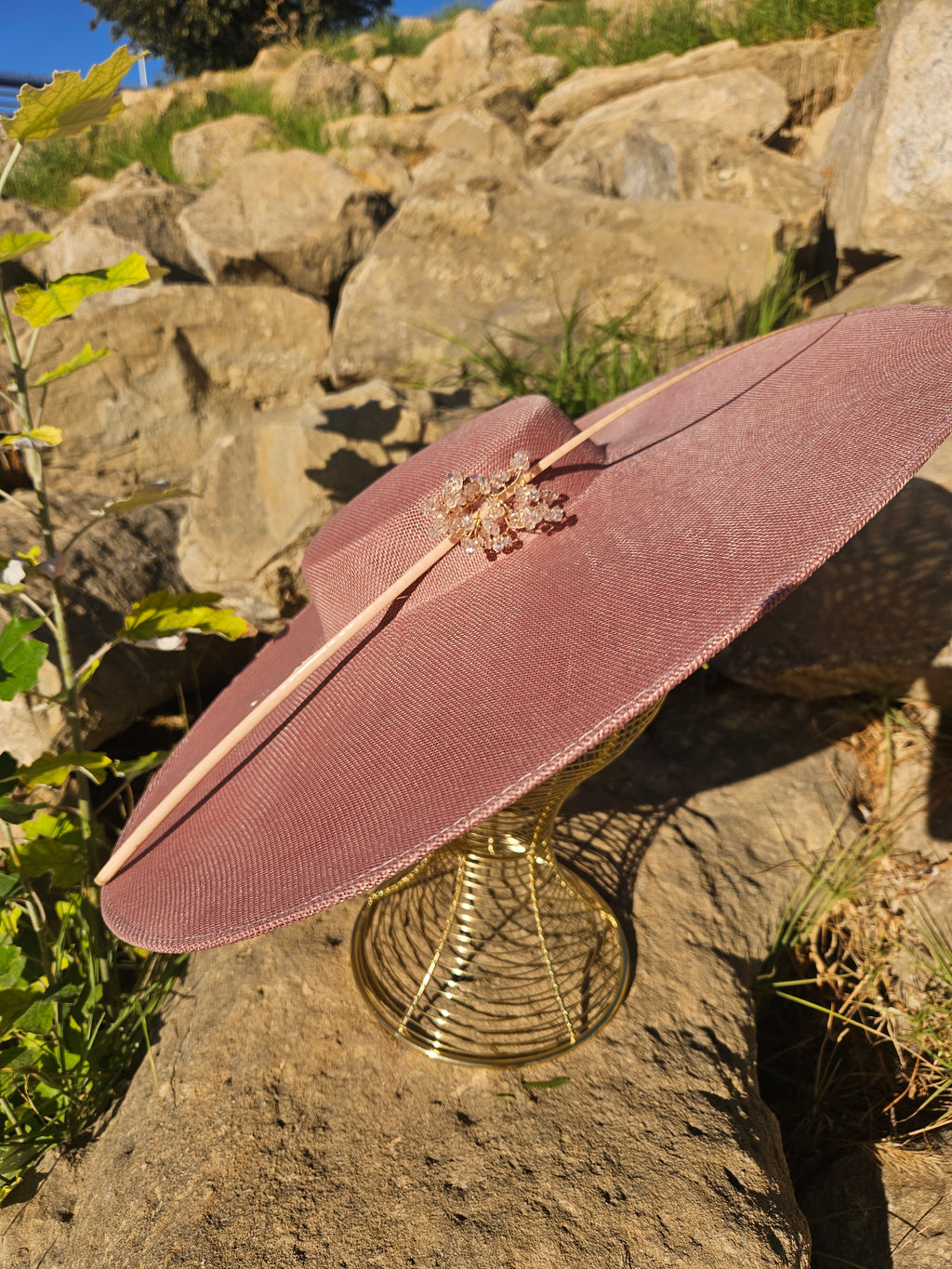 Sombrero Pamela Bella rosa con ala extendida y adorno de pedrería en el centro.
