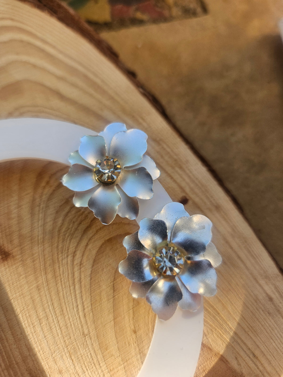 Pendientes de dos flores azules con centro dorado, detalle frontal.