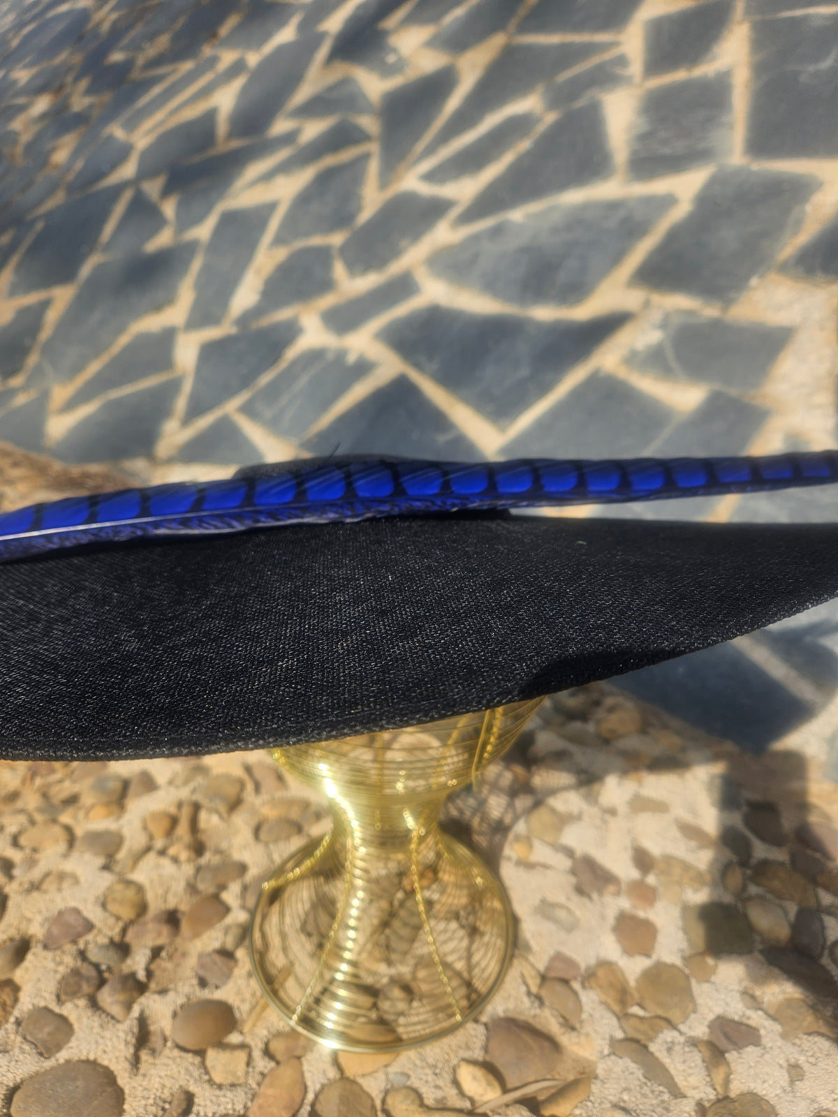 Cinta azul larga sobre ala negra texturizada, con acabado brillante en los bordes
