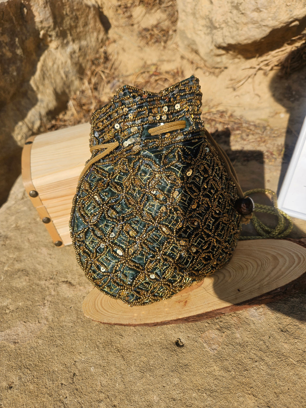 Bolso saco bordado turquesa y dorado con asa trenzada y cordón, acabado con cuentas