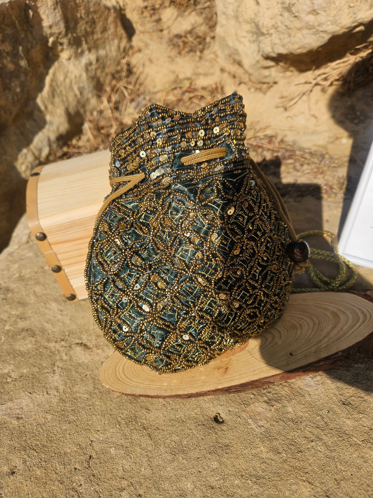 Bolso saco bordado turquesa y dorado con asa trenzada y cordón, acabado con cuentas