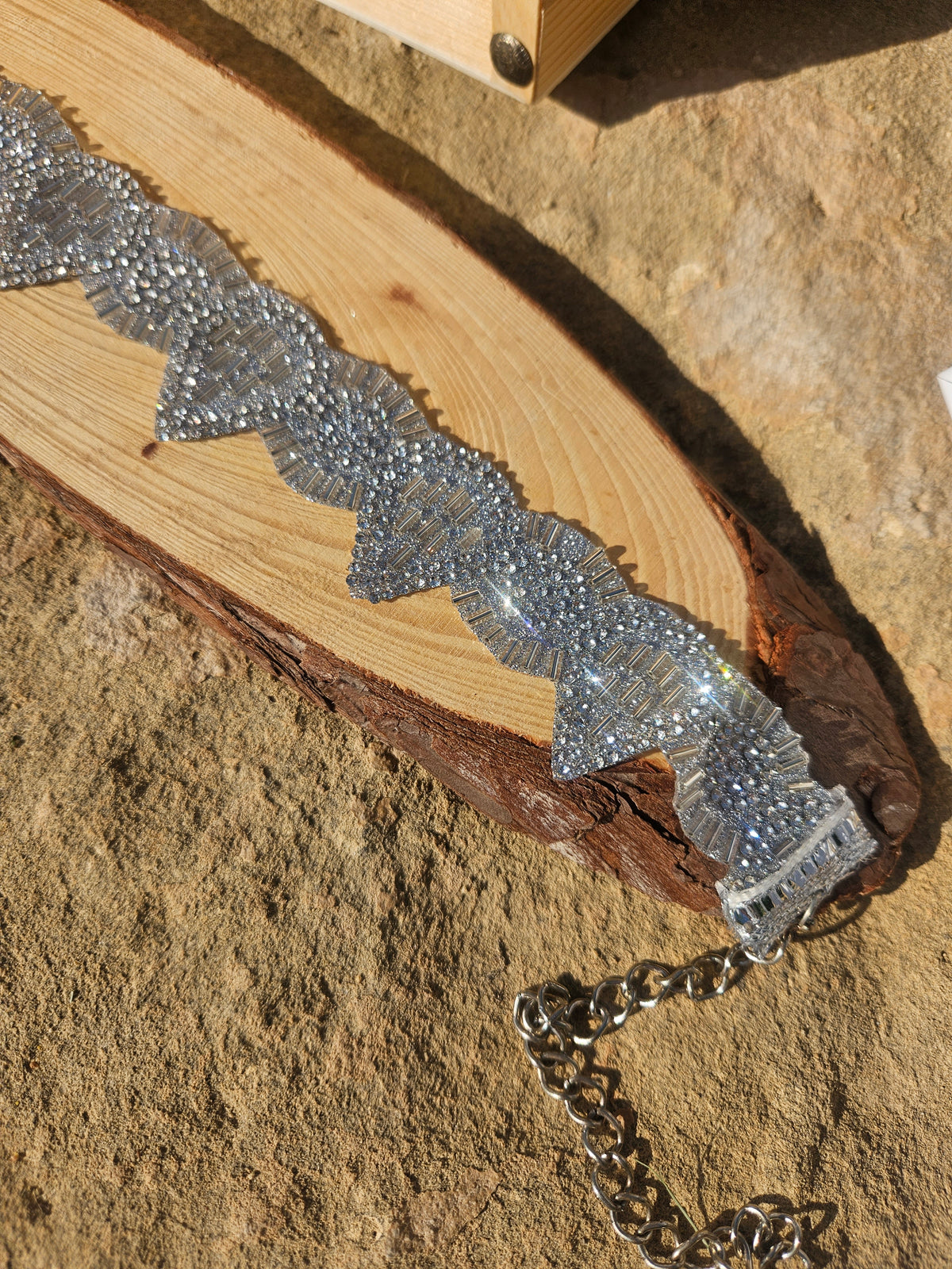 Gargantilla choker plateada con pedrería brillante, dije central y cadena lateral