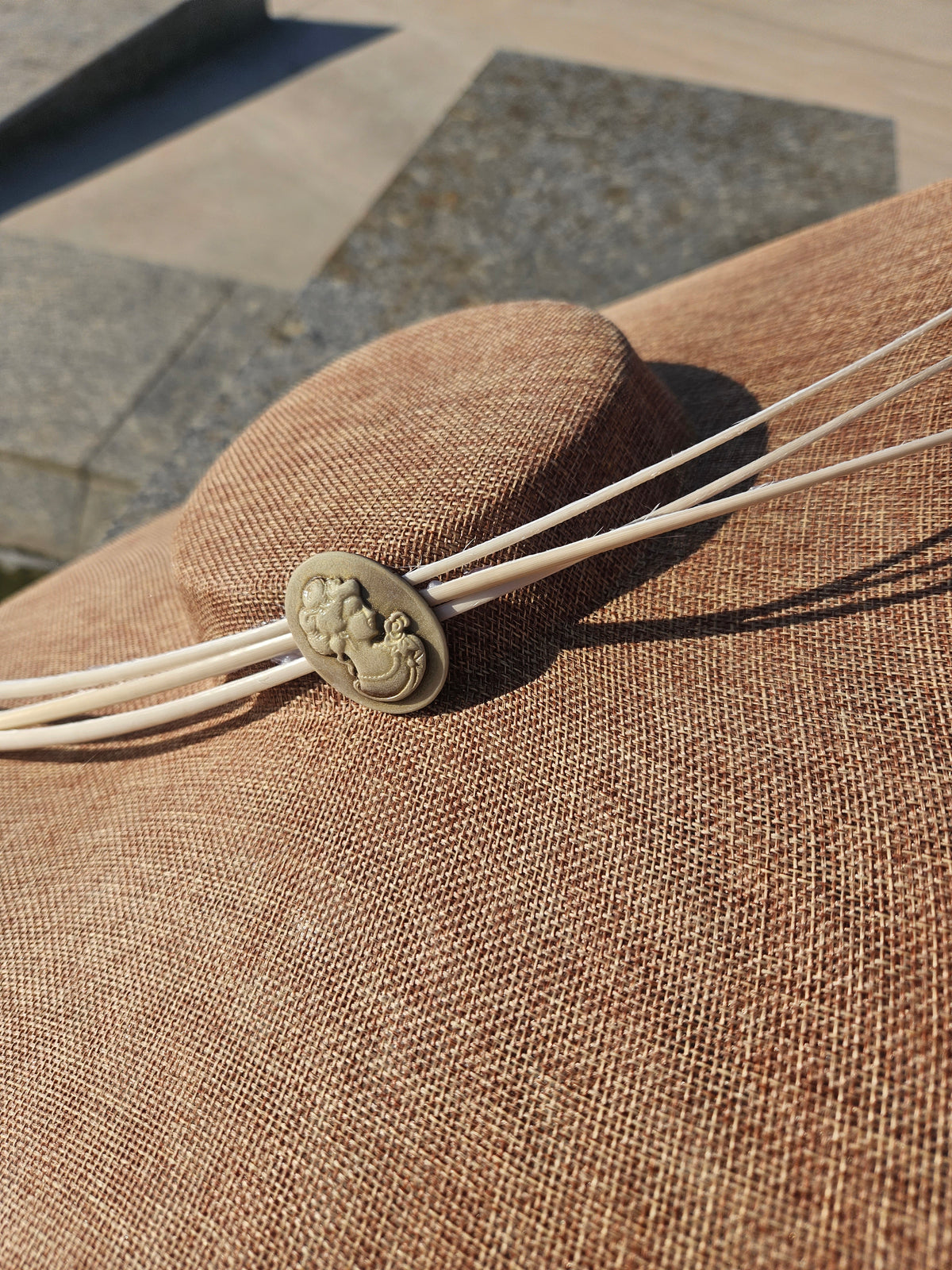 Pamela Santtal beige con detalle central redondo y cordones blancos anudados.