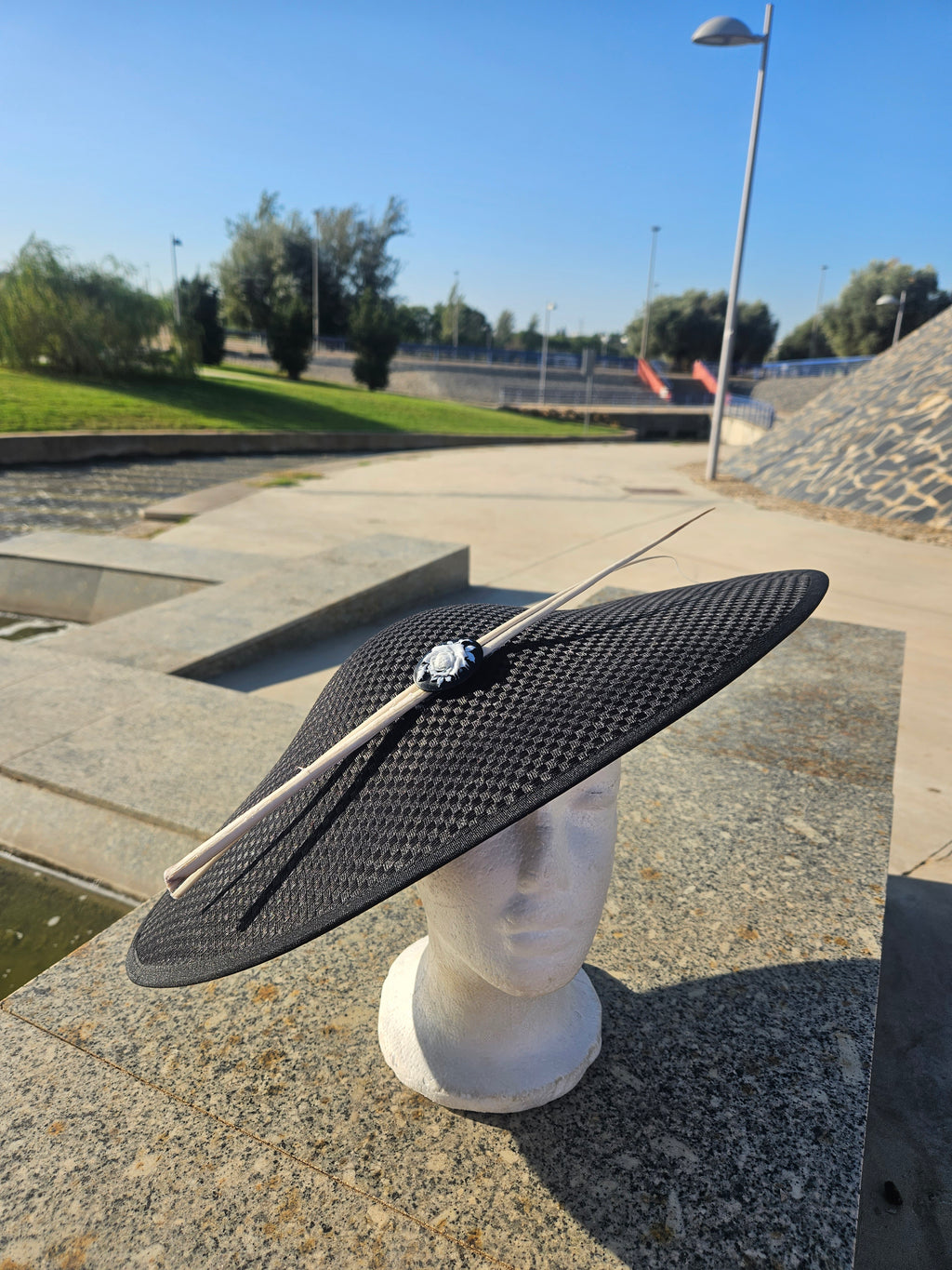 Sombrero pamela negro de ala ancha con adorno floral y lazos claros