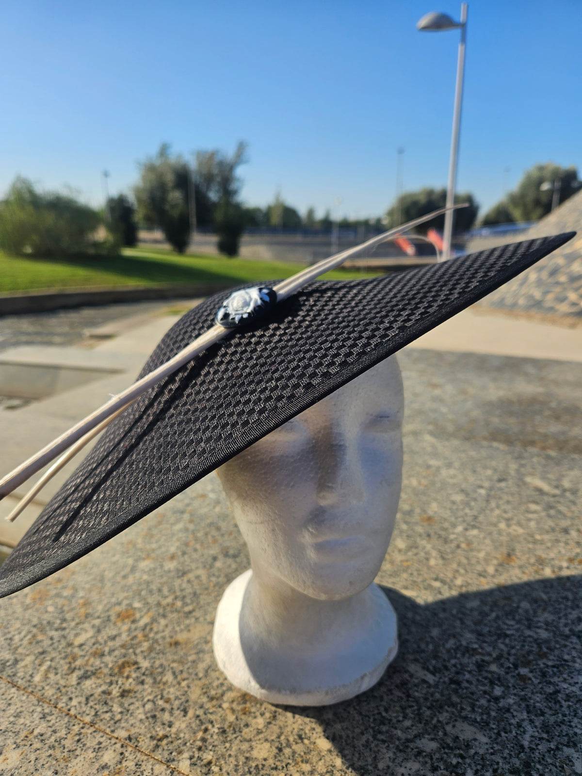 Sombrero pamela negro de ala ancha con adorno circular y lazos de cordón