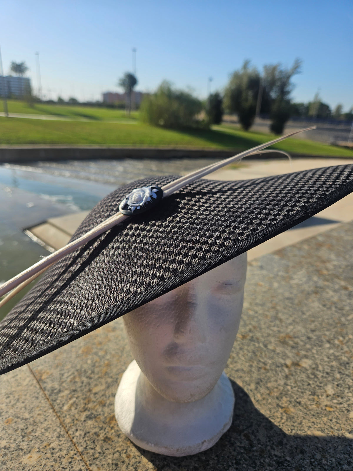 Sombrero pamela negro con ala ancha y broche central con cordones claros
