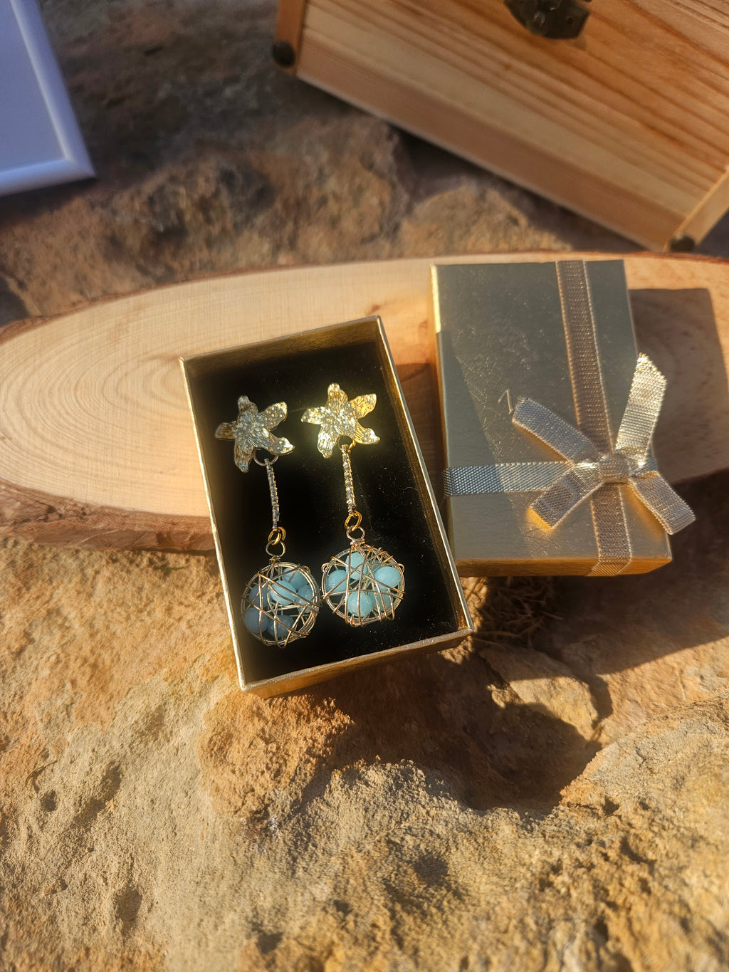 Pendientes Caspio dorados con dijes florales y esferas azules enrejadas colgantes